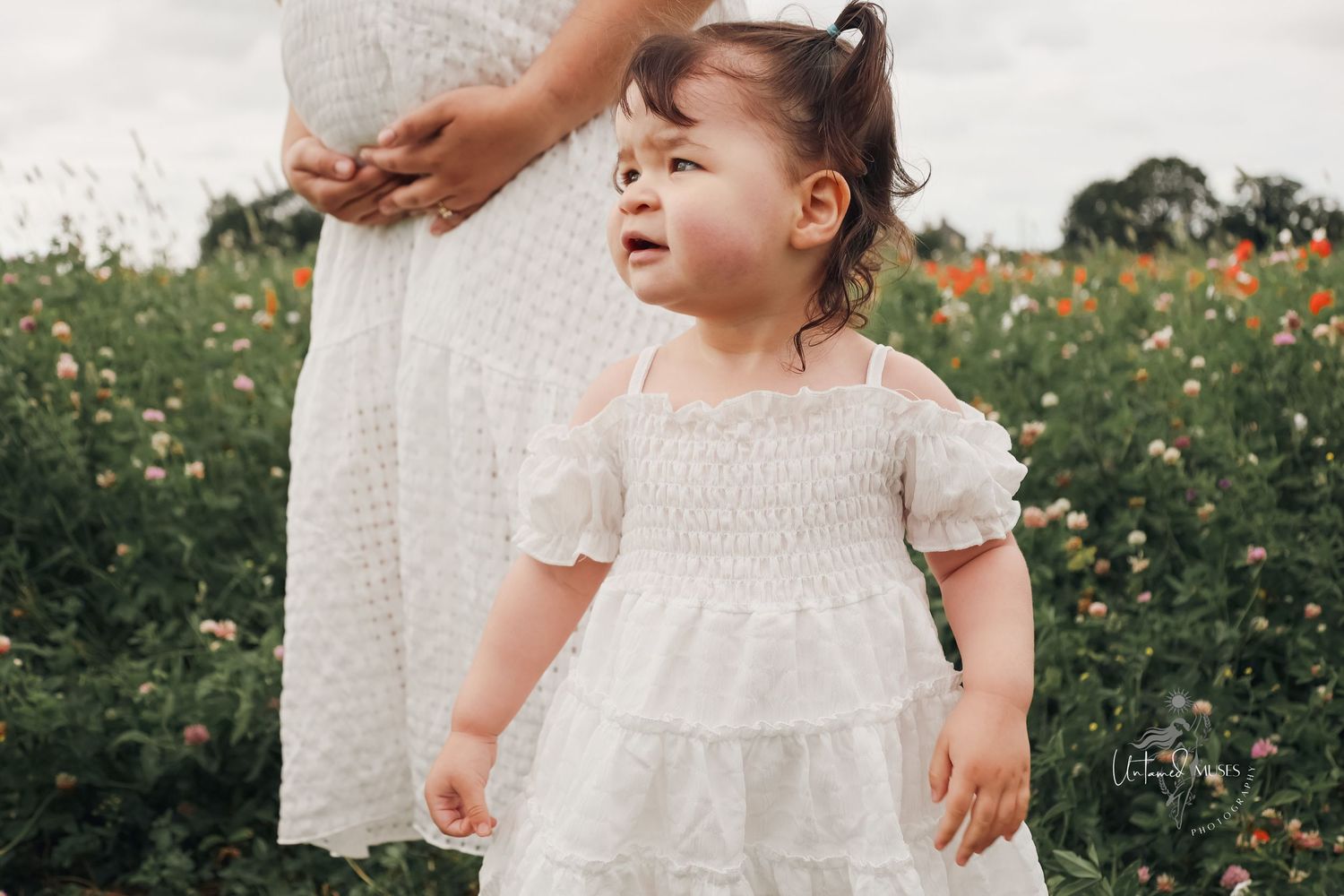 Beautiful portrait from a maternity session in the wild flower fields in Lakenheath captured by the female gaze of Untamed Muses