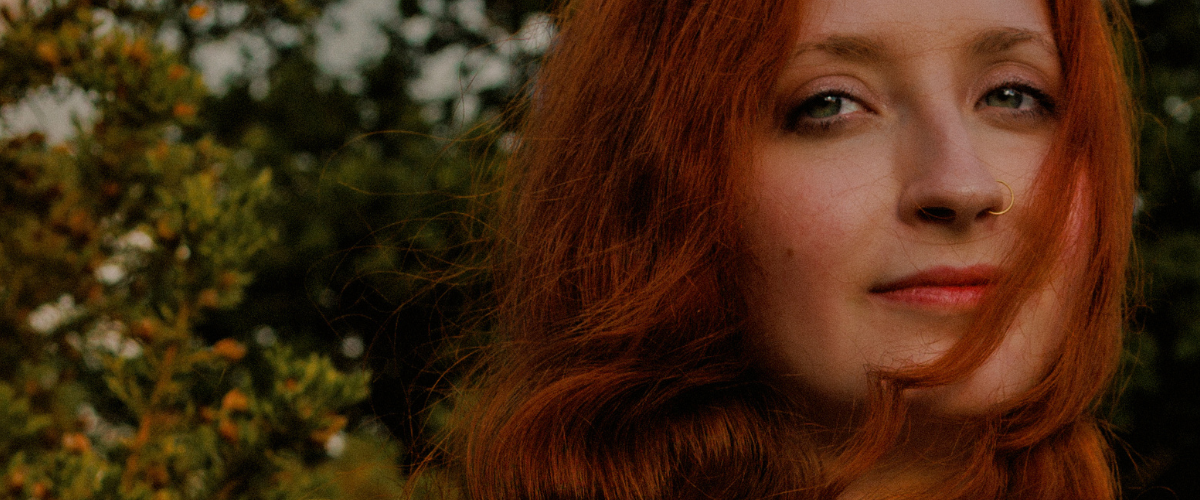 Close up of painterly portrait of a red head Muse in Norfolk fields captured by empowerment specialist , female gaze curator Untamed Muses