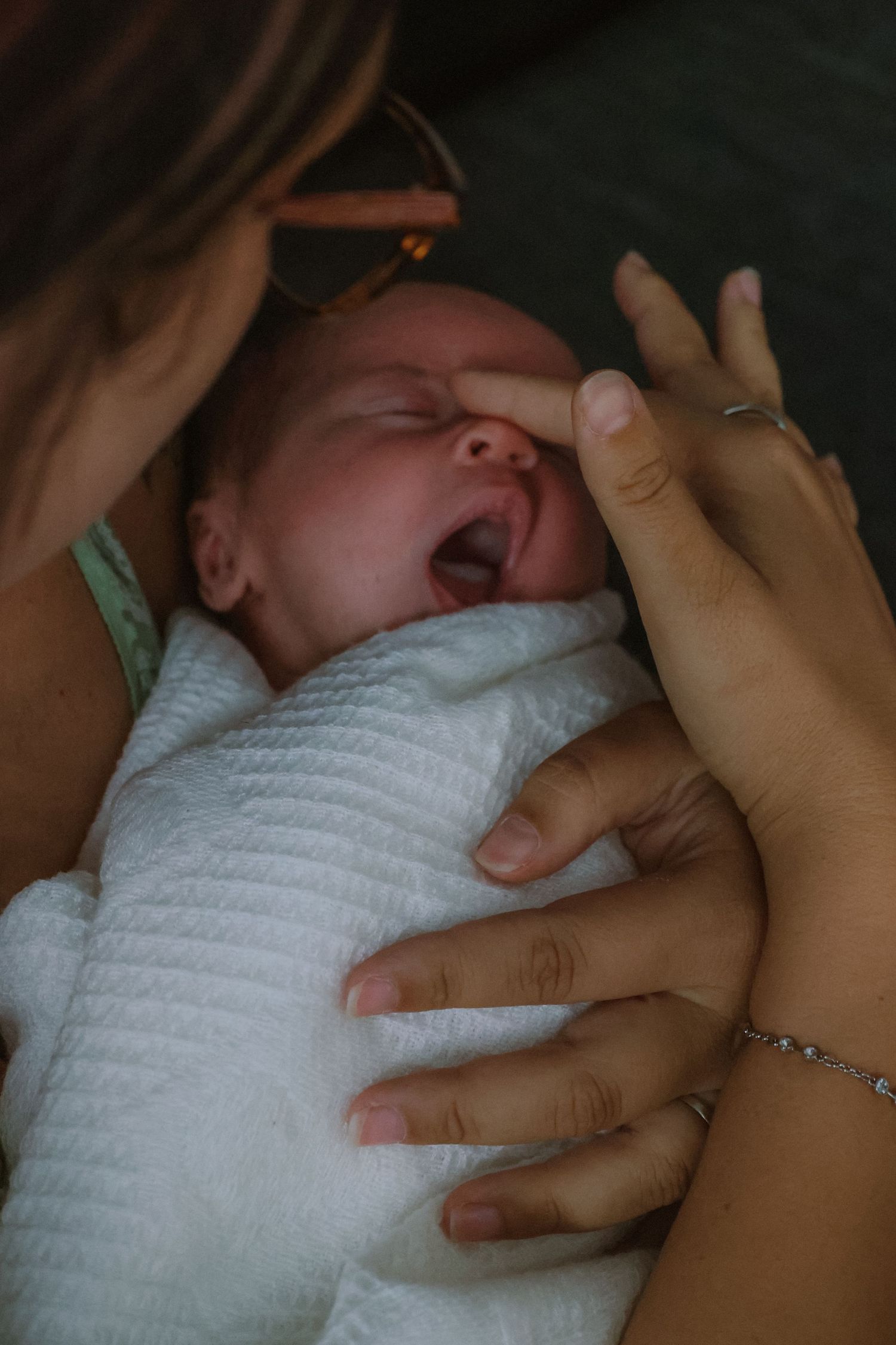 close up during natural newborn photoshoot mum soothing baby girl caressing her nose