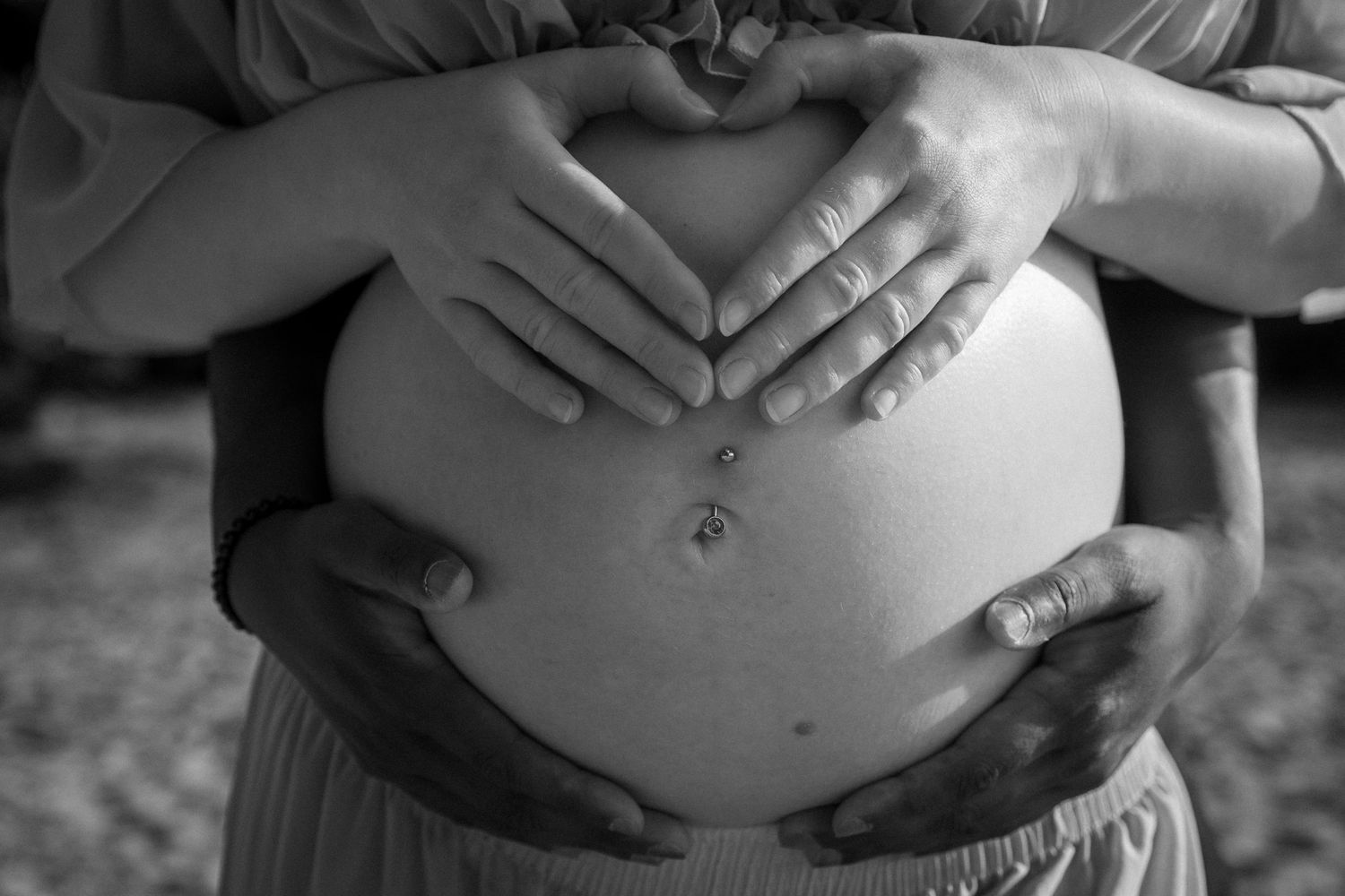 Detail of bump and parents hands biracial couple, black and grey ,timeless maternity session in Norfolk lakes, by untamed muses
