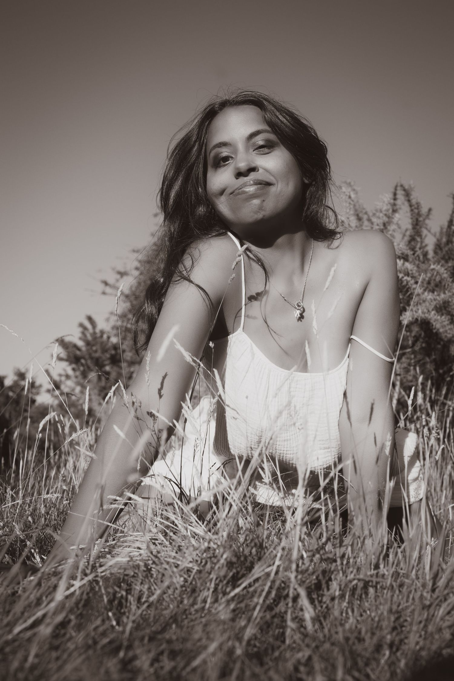 Portrait of woman sat in a field, smiling empowerment photoshoot at Untamed Muses in Thetford, monochrome