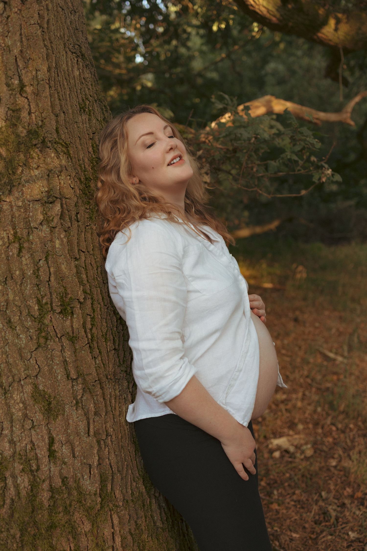 Portrait from a maternity session in a norfolkwoodland, golden light goddess captured by the female gaze of untamed muses