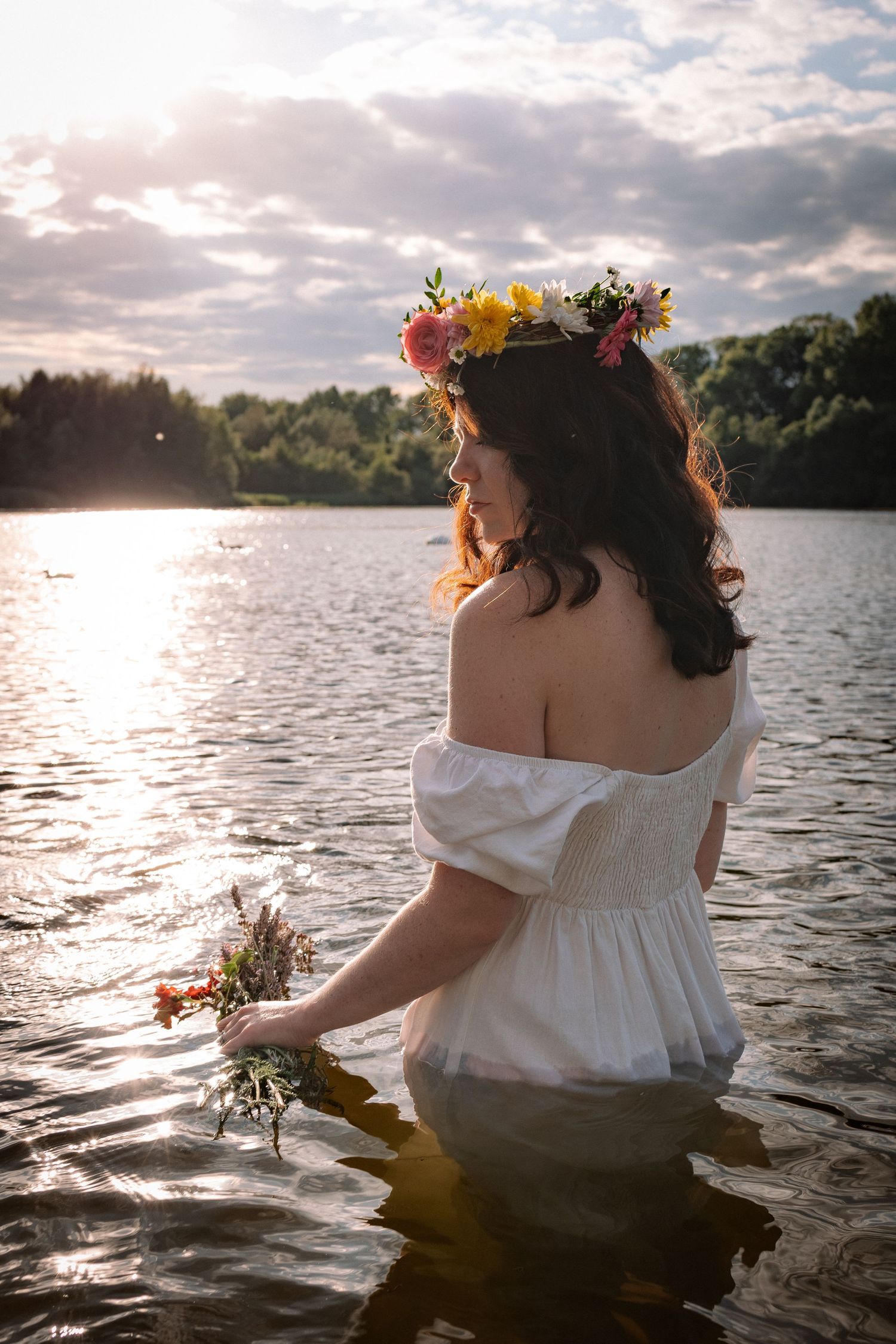 Portrait of woman inside a lake, with a flower crown, during sunset, empowerment photography in East Anglia