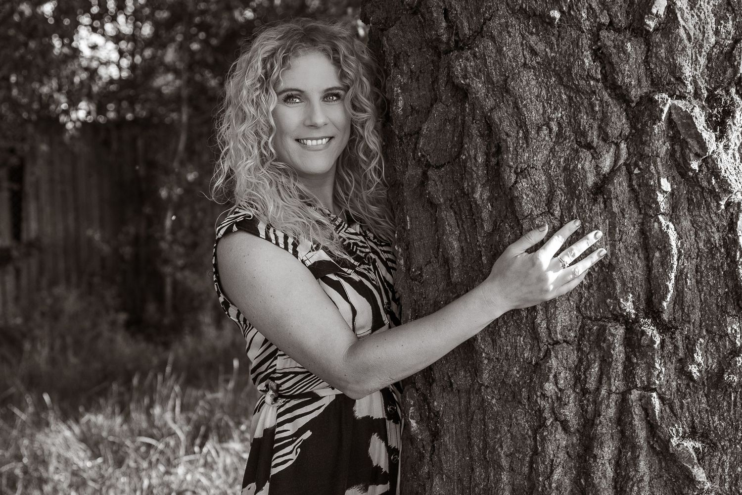 lifestyle portrait, female empowerment , beautiful monochrome portrait of women smiling huffing a tree, in ipswich