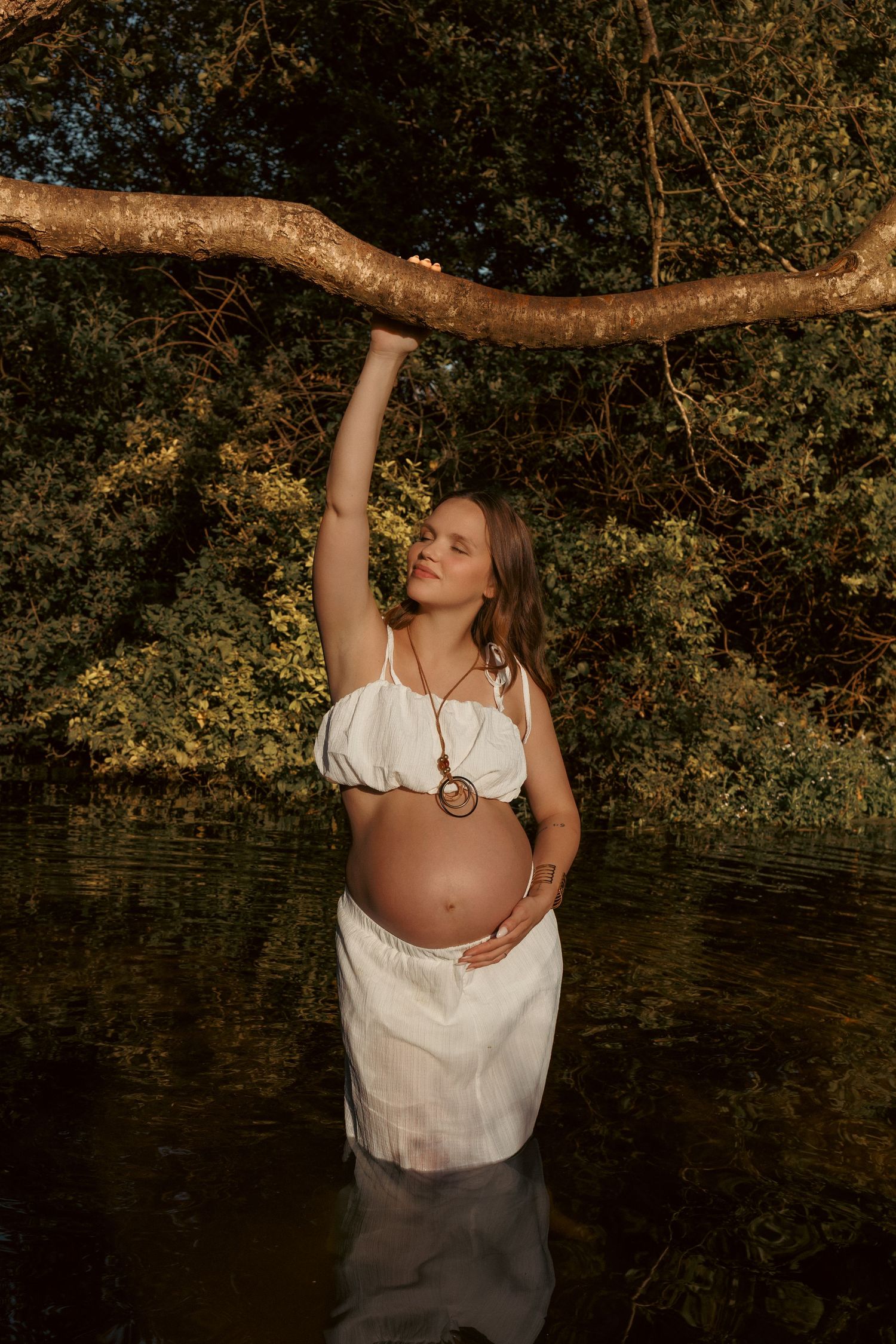 Beautiful portrait from a maternity session in a norfolk river, golden light goddess captured by the female gaze of untamed muses