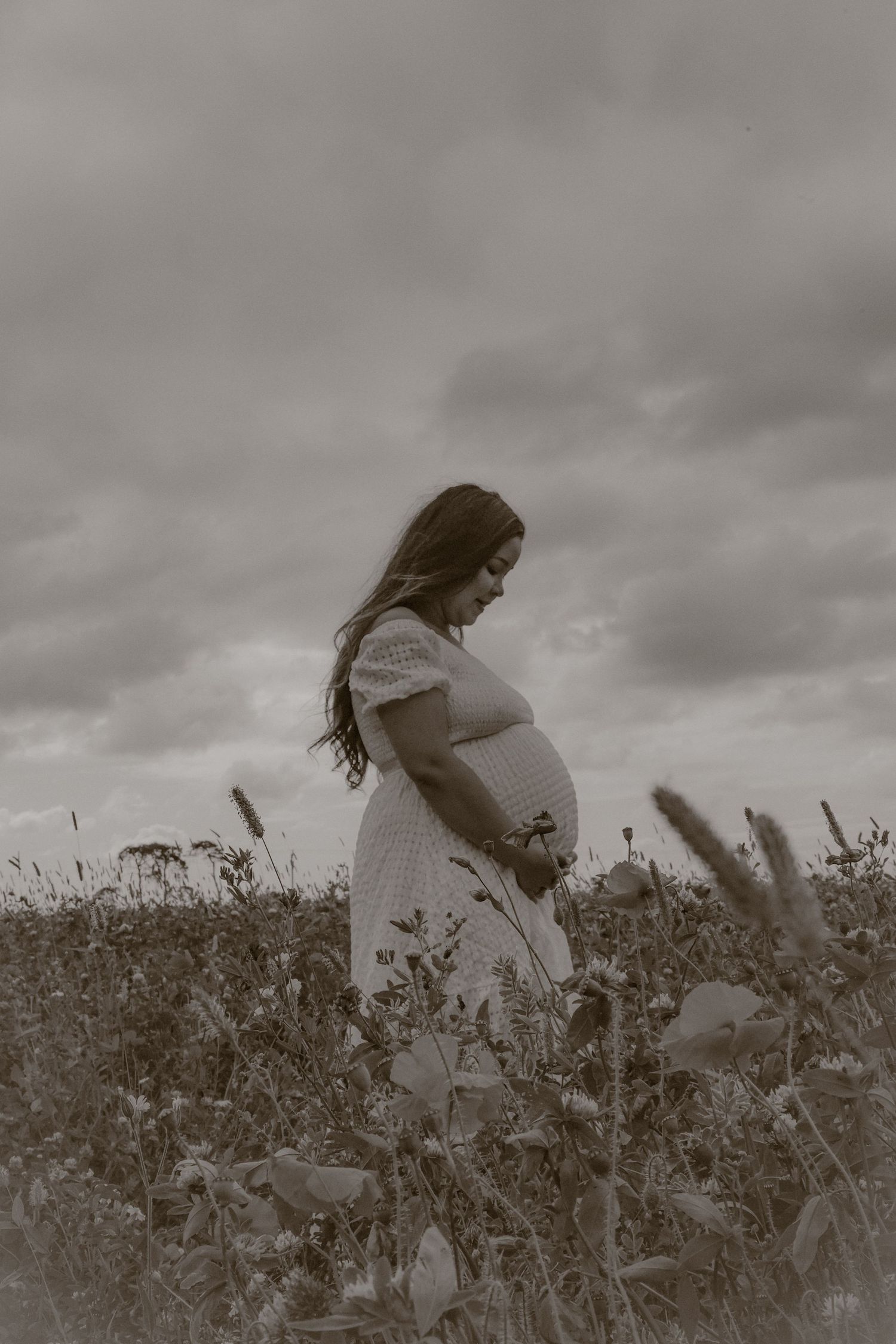 cinematic, monochrome portrait of woman in a wild flower field in Suffolk, captured by Maternity photography specialist Untamed Muses
