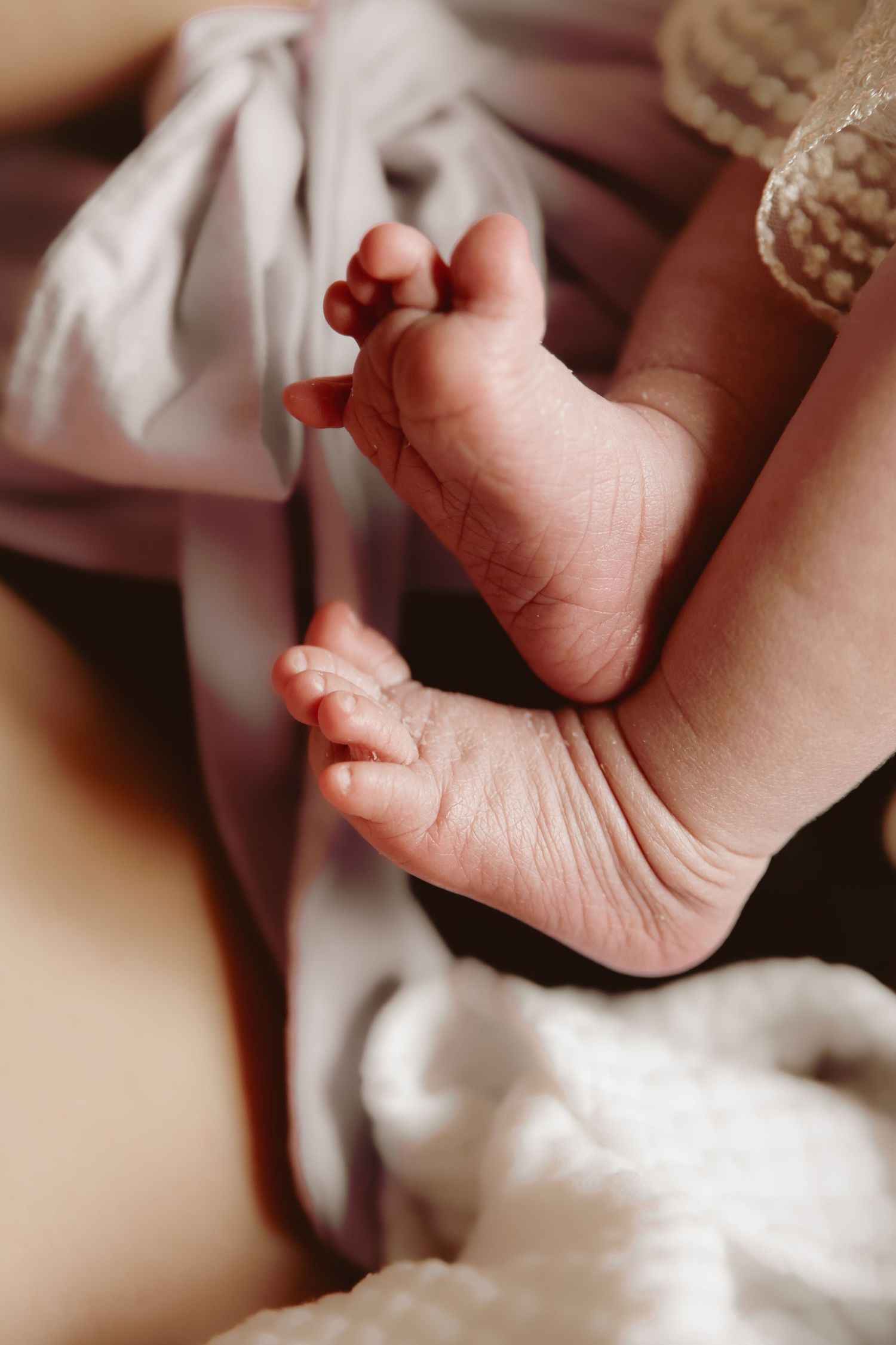 detail of newborn feet during a natural newborn at home photography session by Untamed Muses in East Anglia, documenting real connection