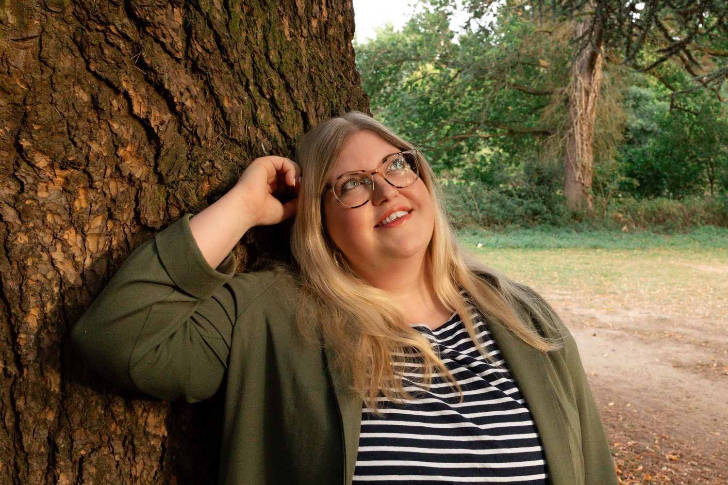 personal branding portrait of woman leaning against a tree, smiling , in norfolk