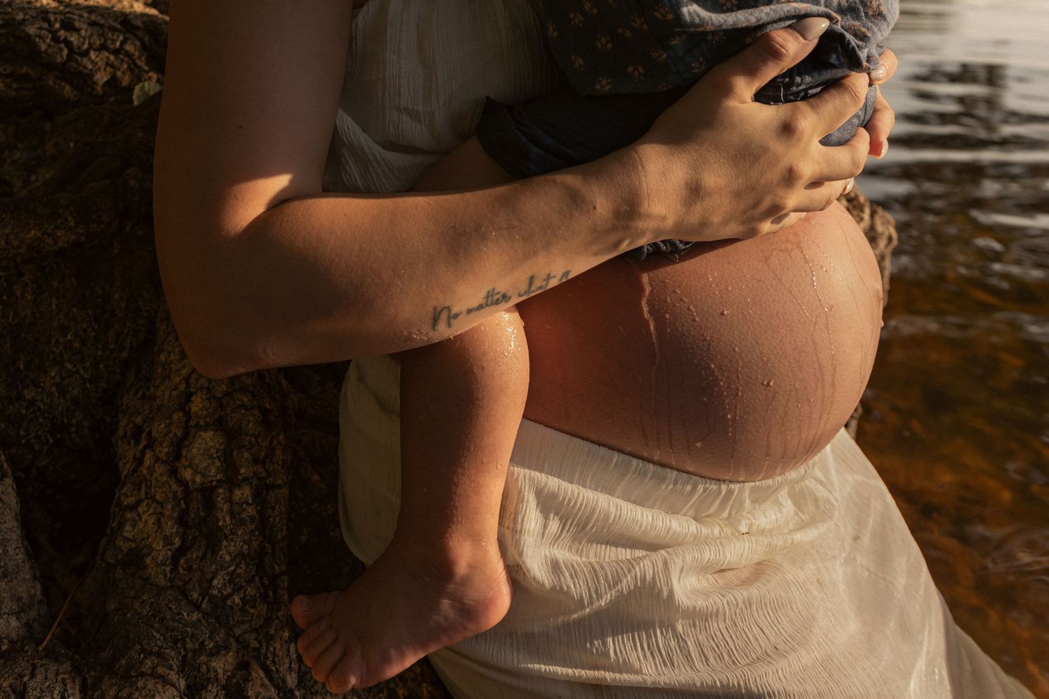Close up of emotive embrace between pregnant mother and baby in the Norfolk river , Thetford maternity photographer