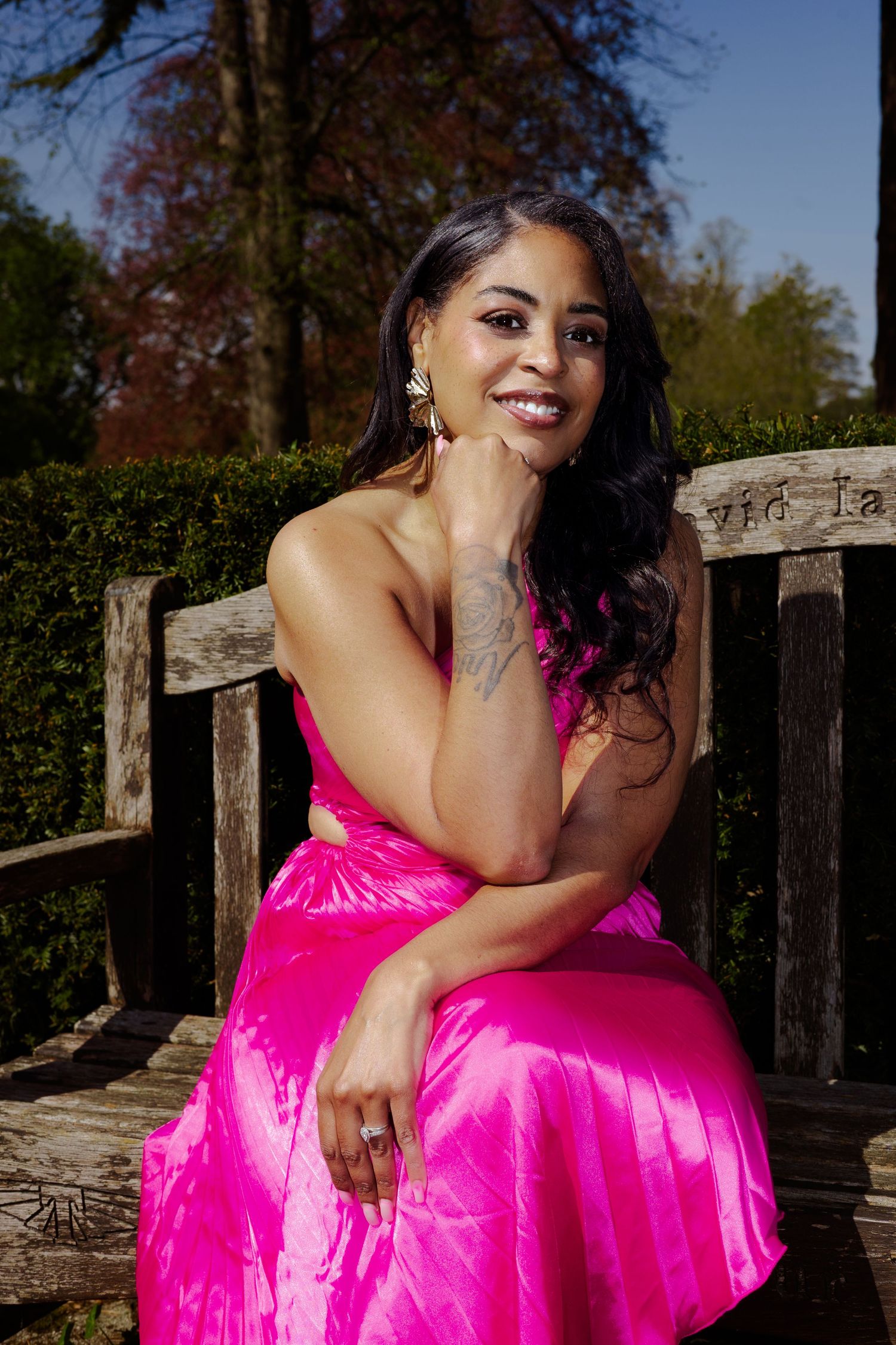 Lisha Soanes, sat on bench smiling, wearing a bright pink dress, Suffolk personal branding by Untamed muses