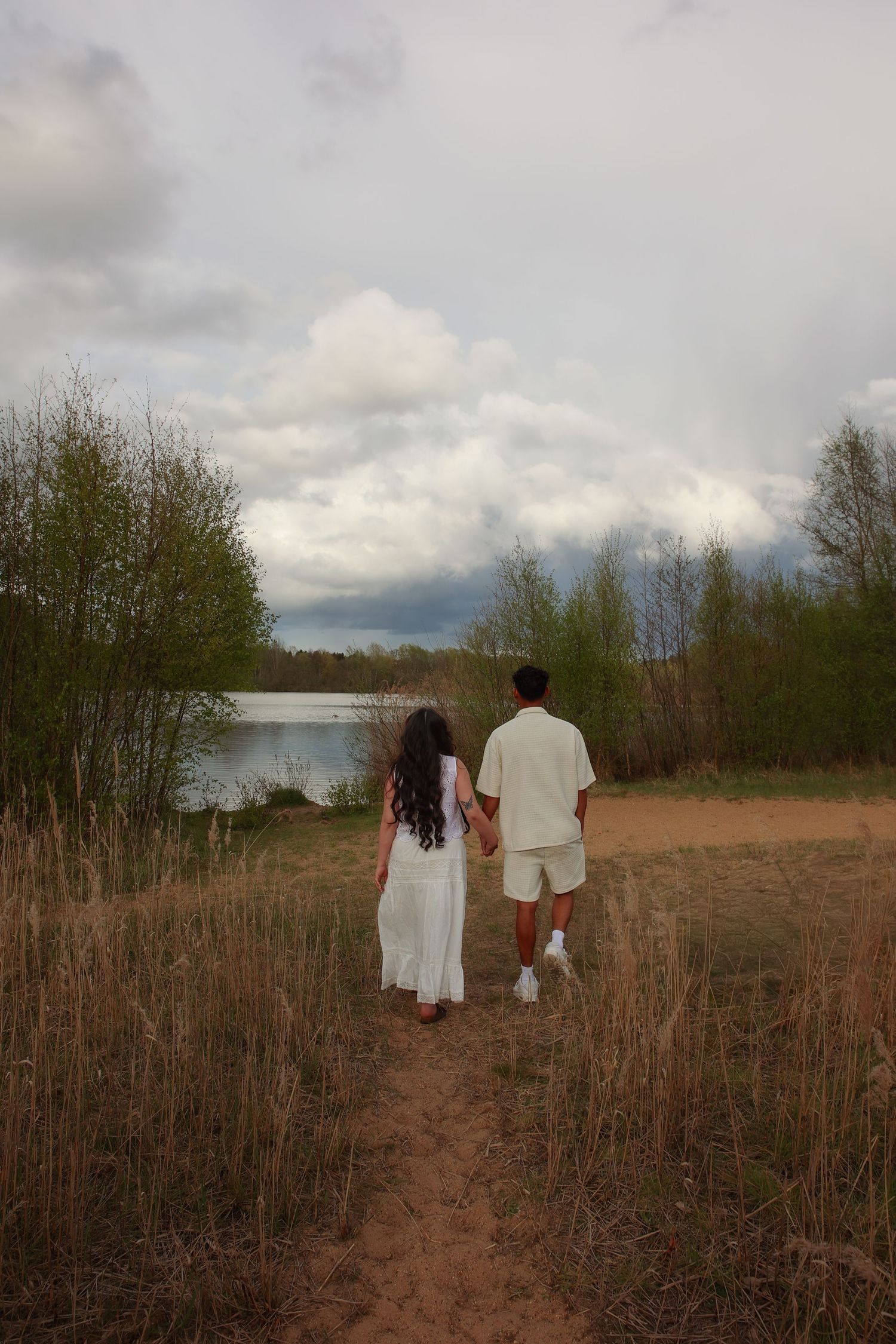 Natural light, couple holding hands during maternity photoshoot with untamed muses photography , outdoors during a spring evening in Norfolk
