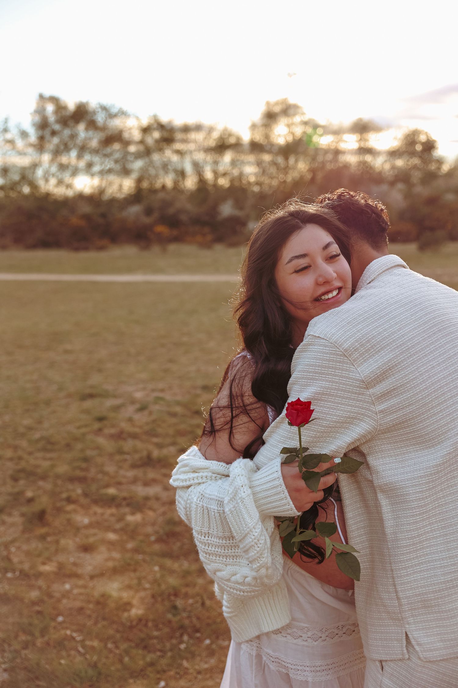Candid photo of couple hugging during maternity photoshoot with untamed muses photography , outdoors during a spring evening in Norfolk