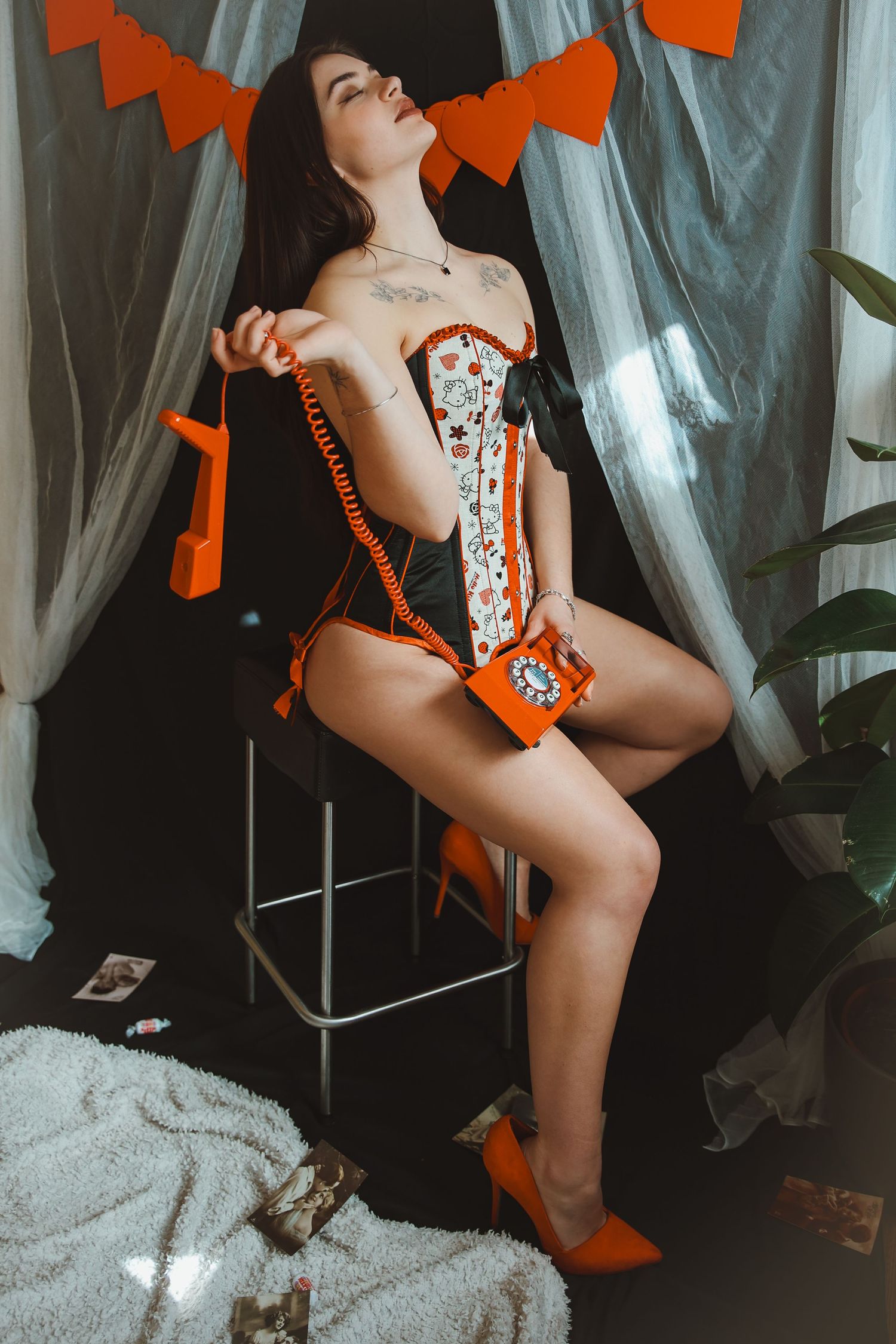 Pin up portrait of woman holding vintage phone ,wearing a hello kitty corset by Bibian Blue, during a boudoir photography shoot in Thetford