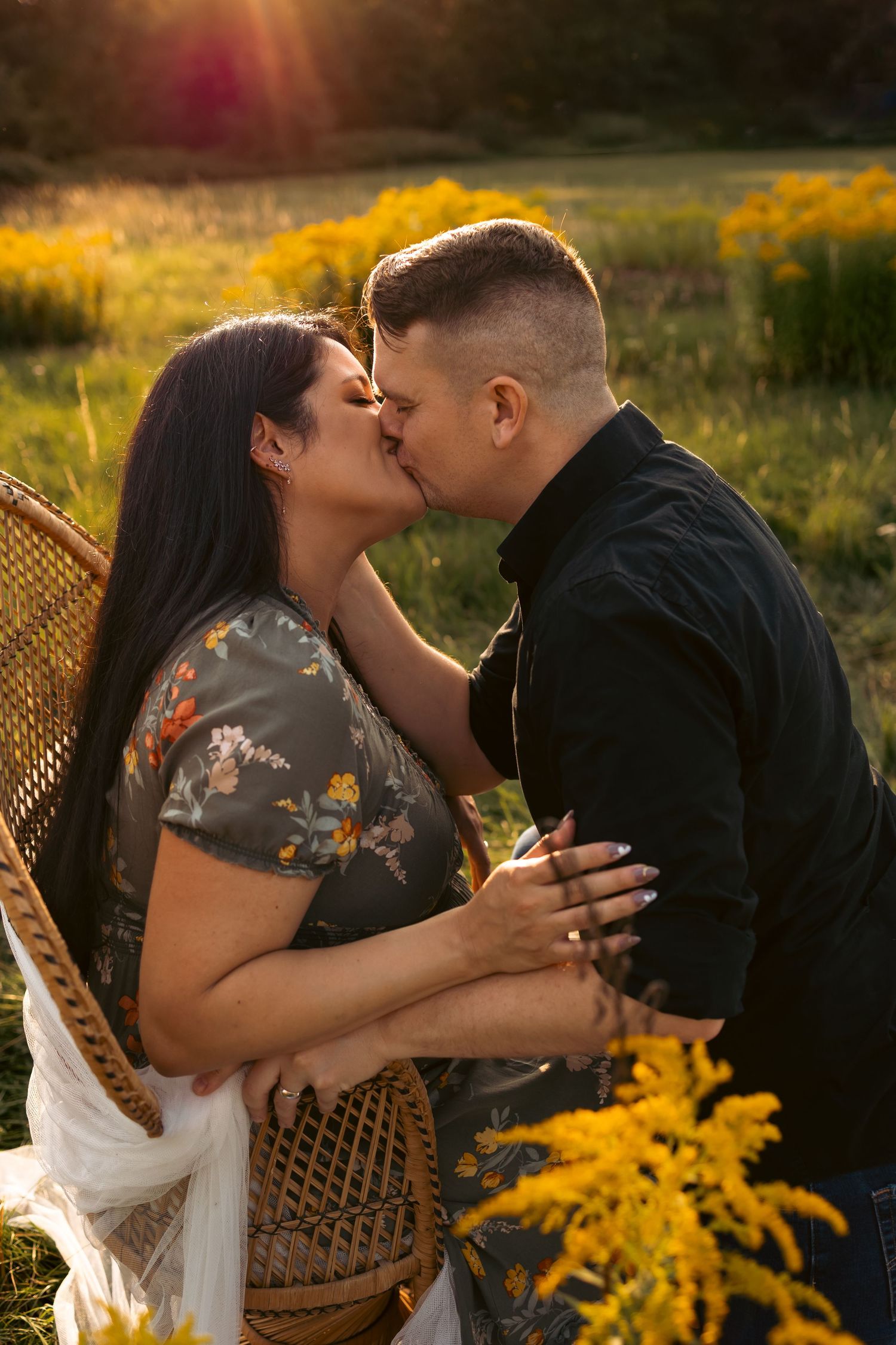 Expecting couple sharing a tender kiss in Norfolk ,bathed in golden light and surrounded by nature, maternity photoshoot by untamed muses