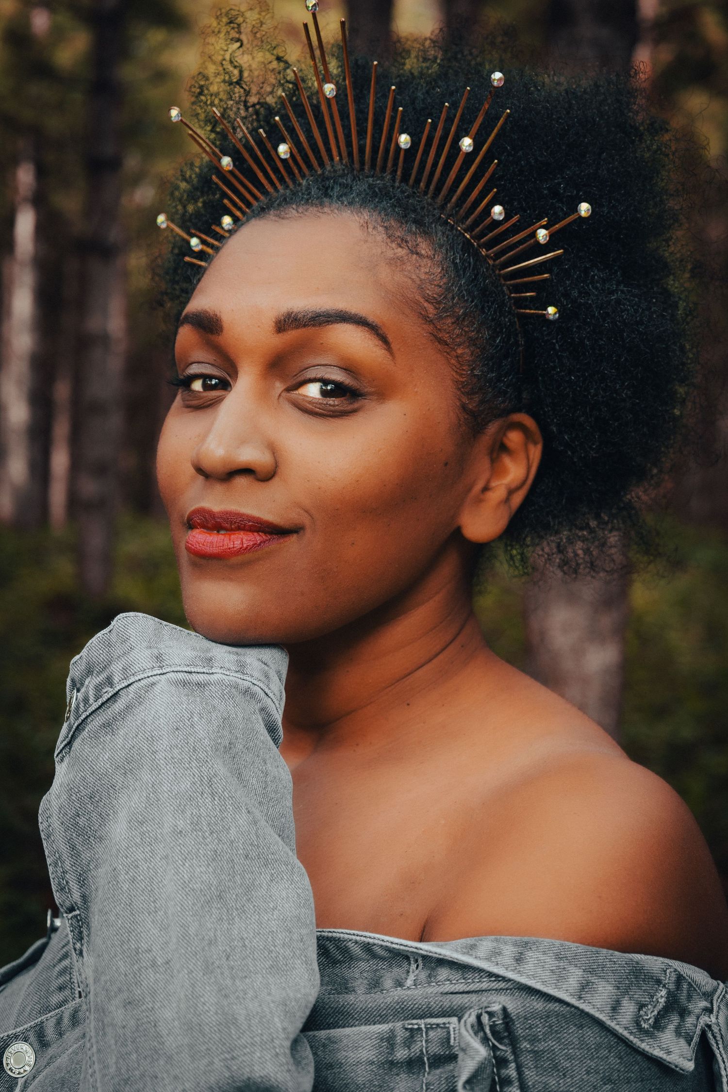 Portrait of a gorgeous black woman in the forest, wearing a crown , staring directly at the lens, with quiet confidence of self-love