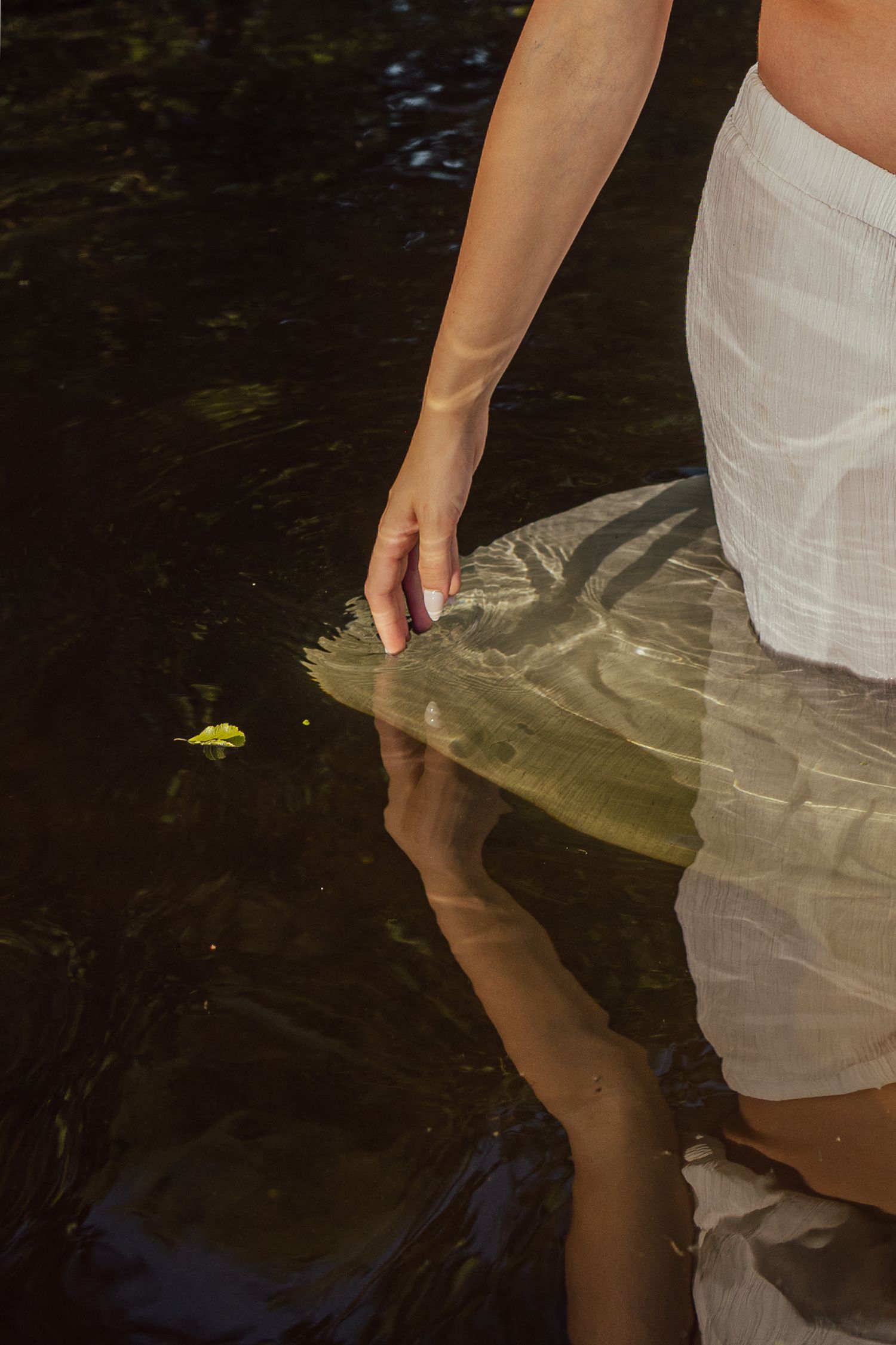 details of hand in water in the river during a maternity shoot, delicate ripples. colour