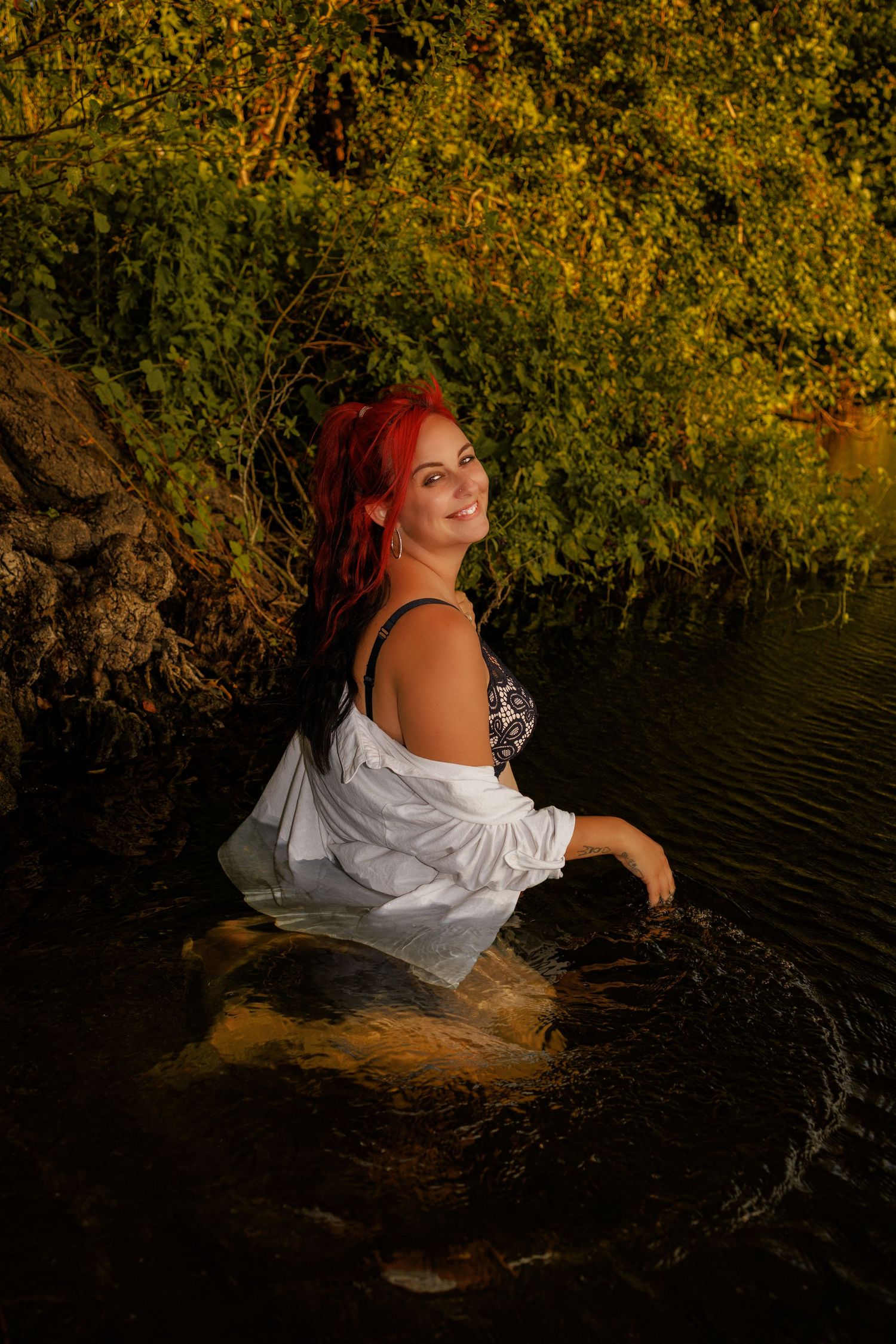 Joyful Portrait of woman in river during her empowerment boudoir photoshoot with Untamed Muses in Thetford