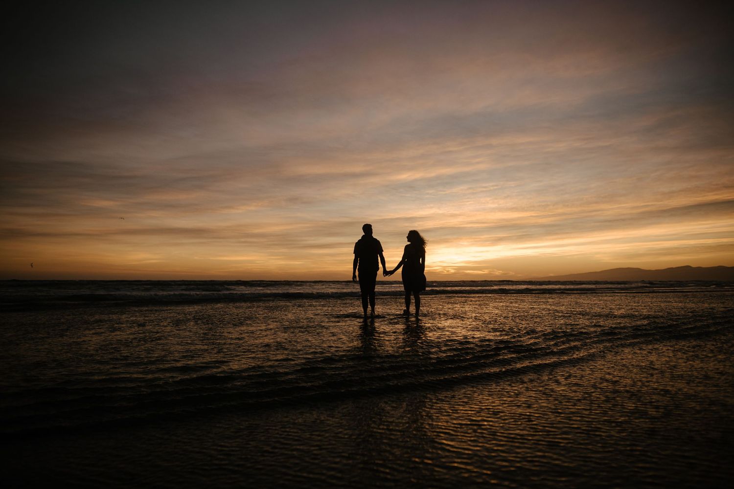 Silhouette by New Brighton pier — morning sunrise engagement photography.