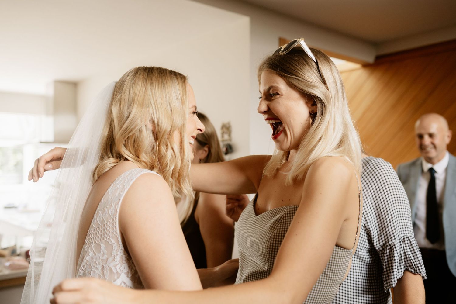 Excited friend hugging bride at rural Canterbury wedding