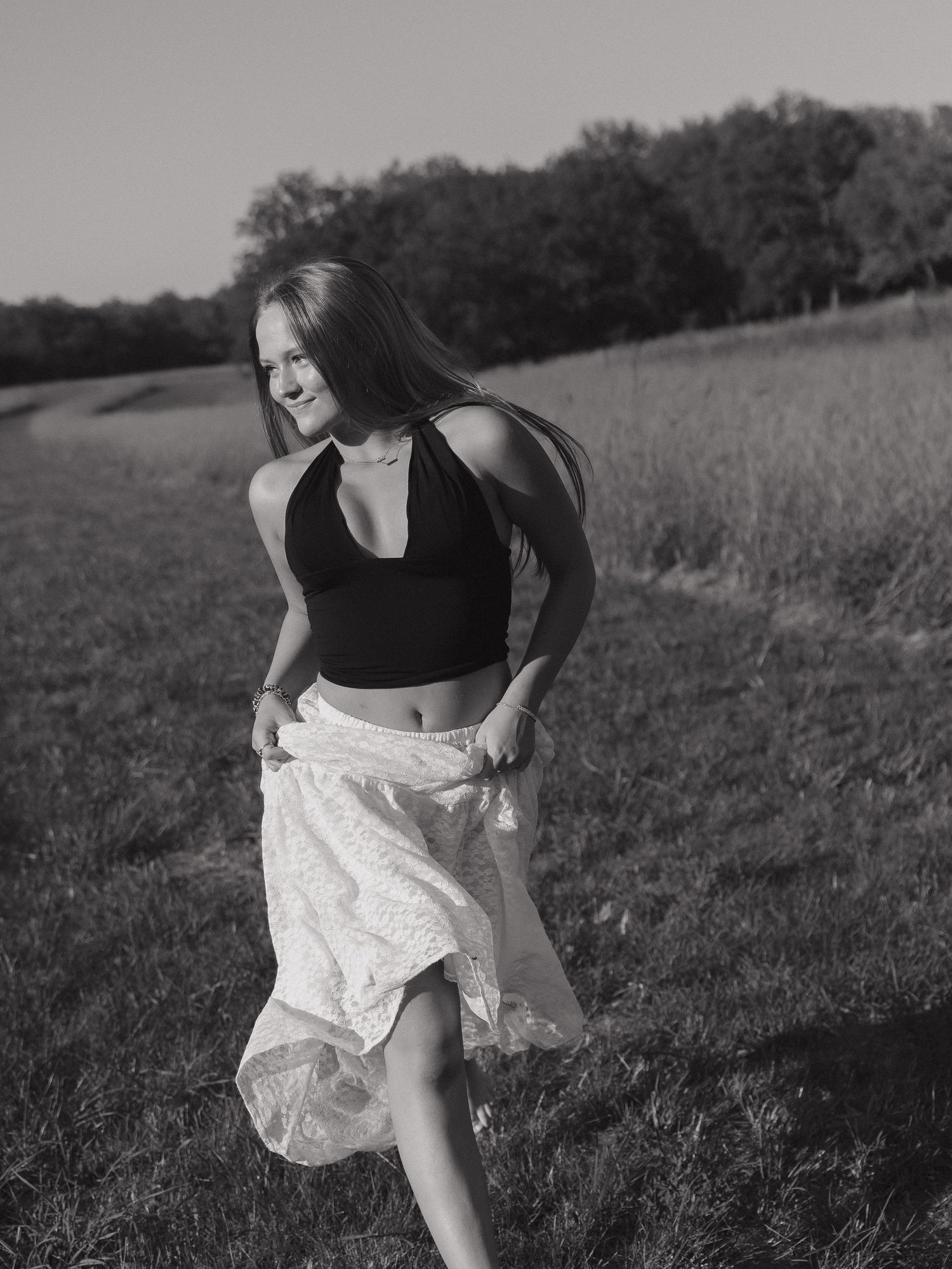 Graduate walking through field in natural light