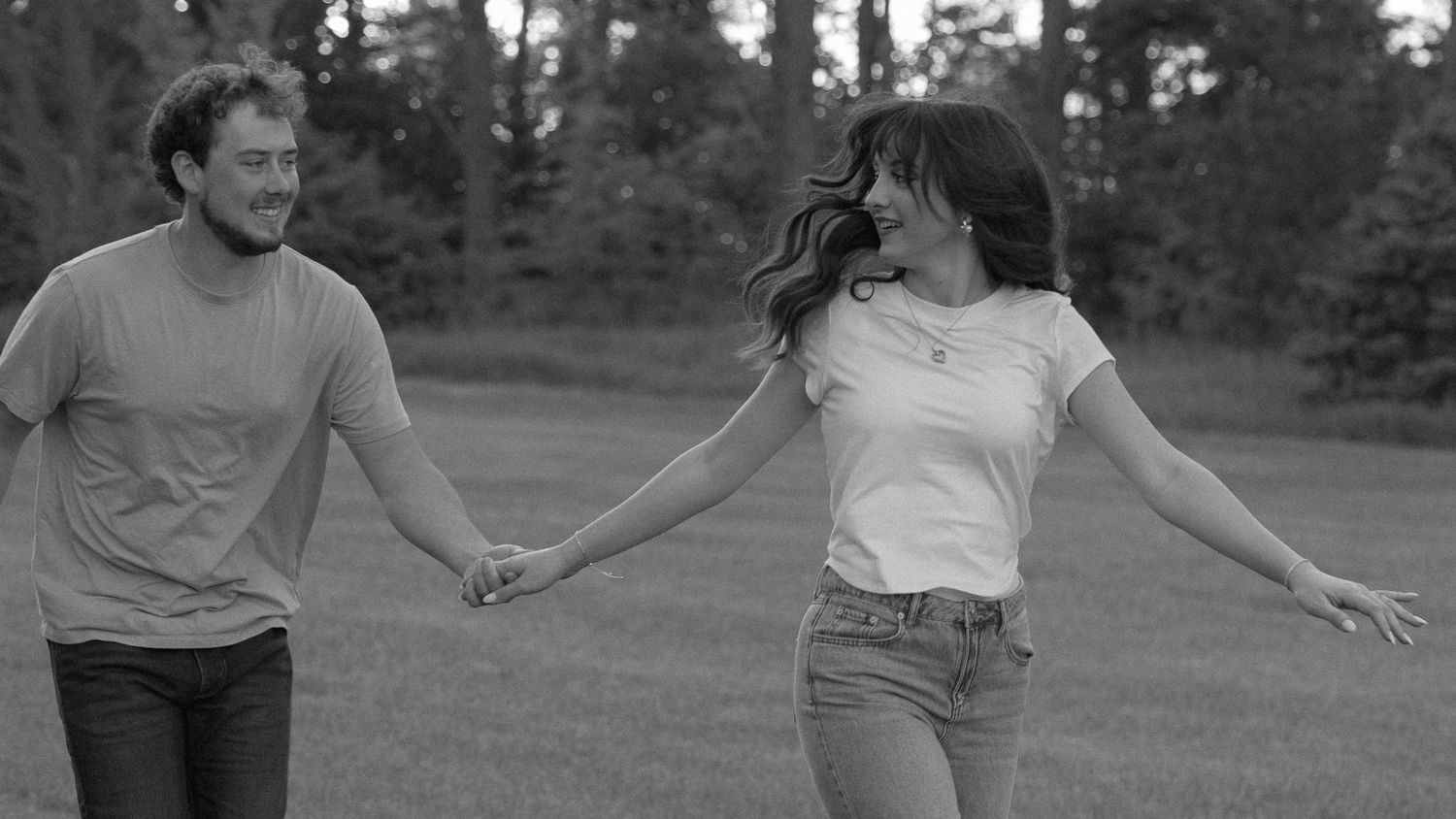 candid couple running through a field together