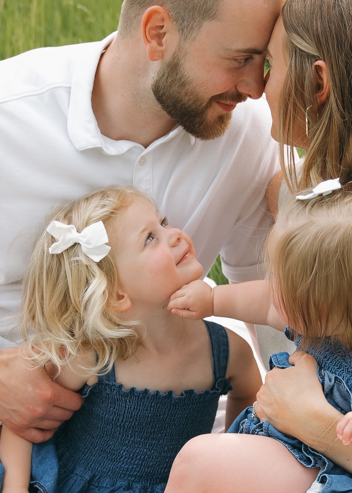 close up child smiling at parents candid family momemt with golden bright lighting
