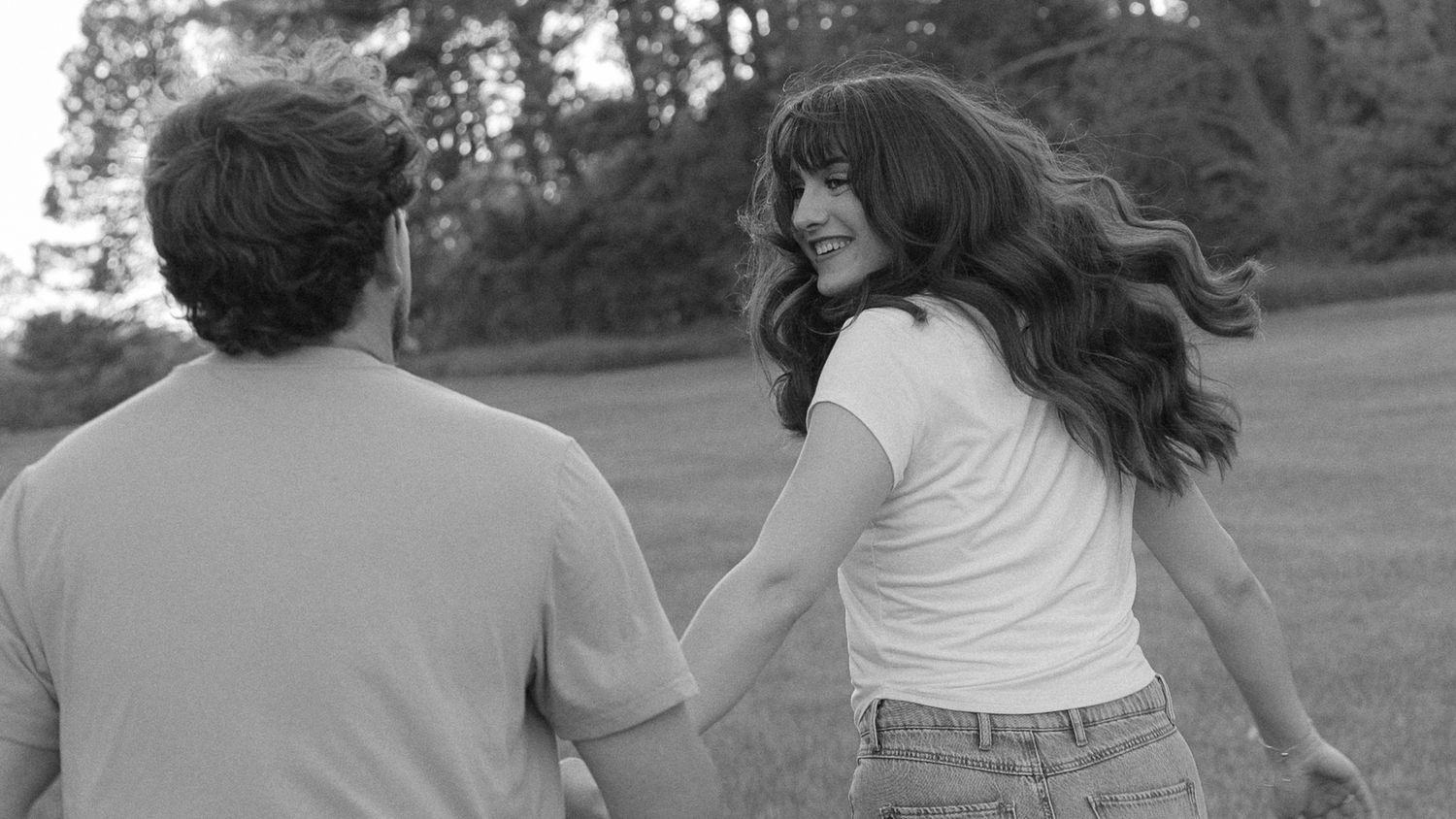 candid couple running through a field