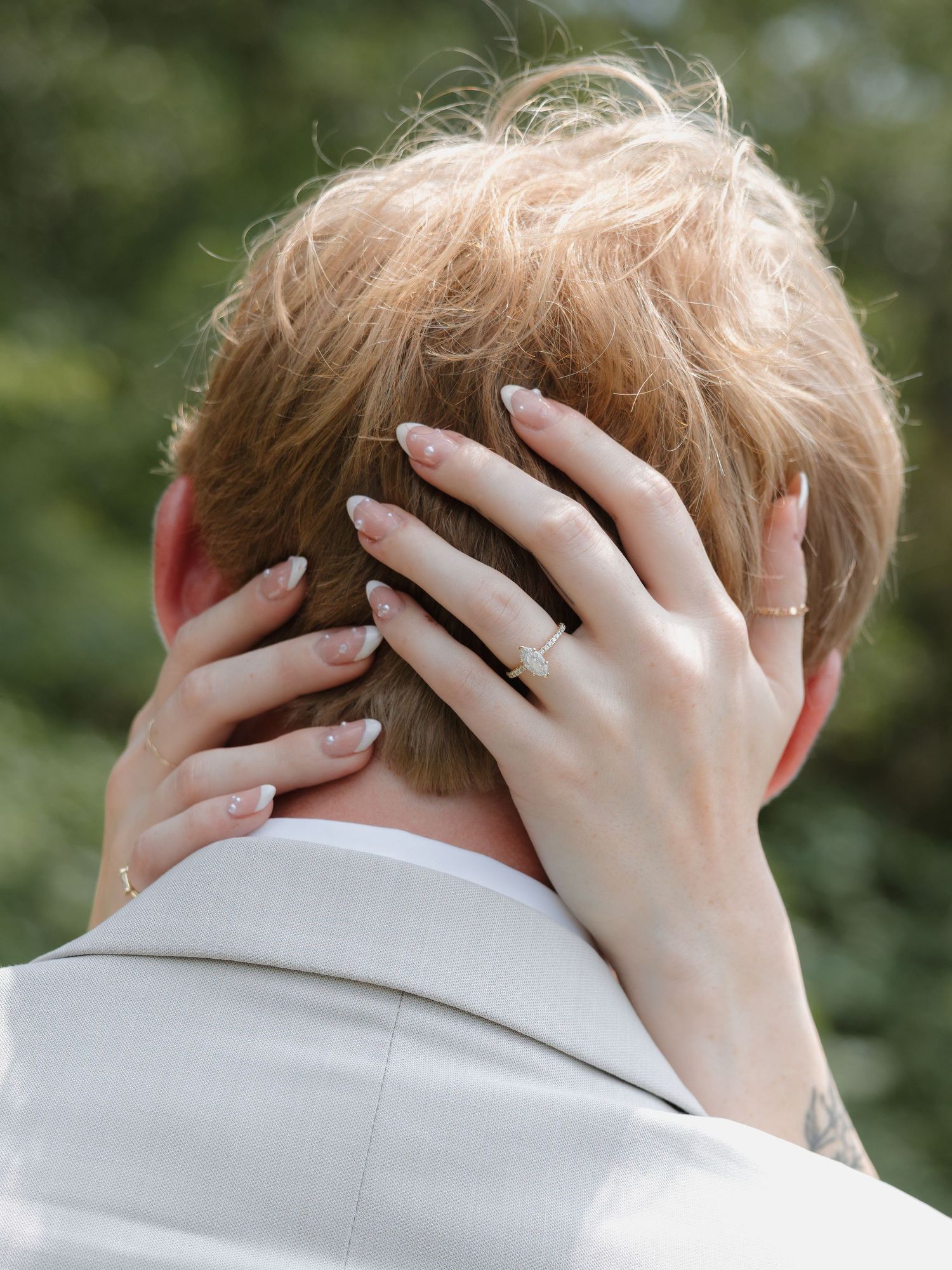 bride holding grooms head with wedding ring in soft glowing lighting