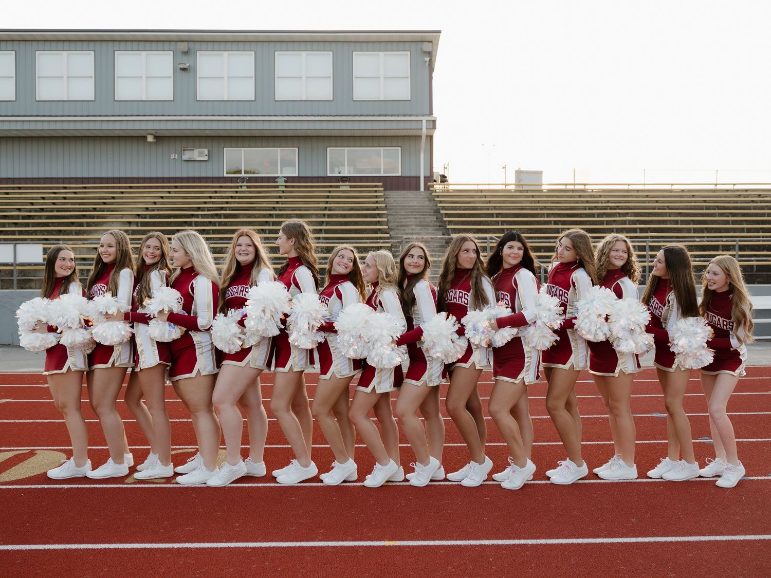 cheer team posing together on their football field