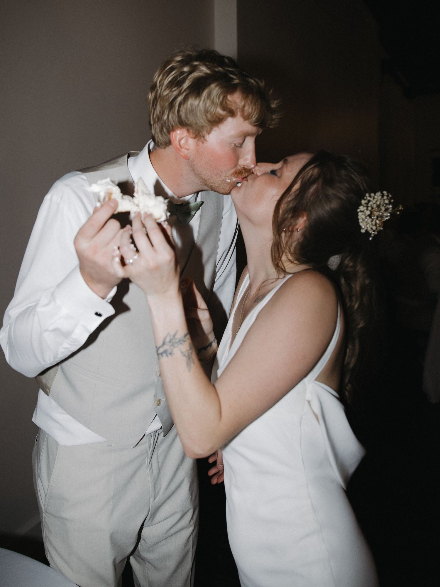 Candid wedding moment of couple laughing and cake cutting flash photography