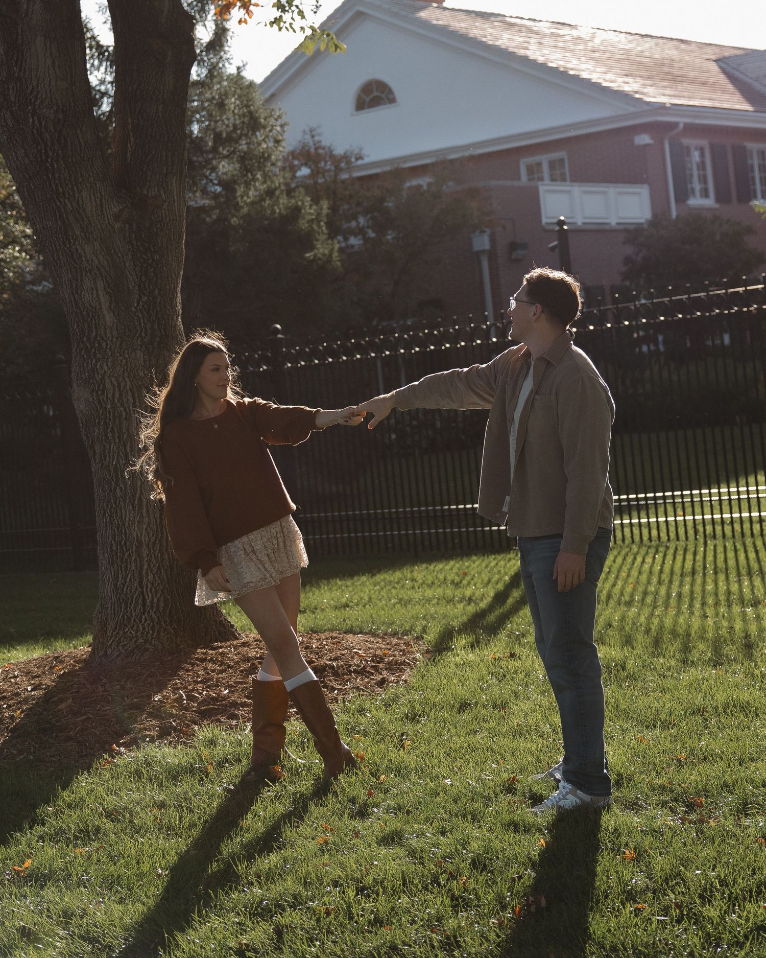 Engaged couple smiling at each other in natural light