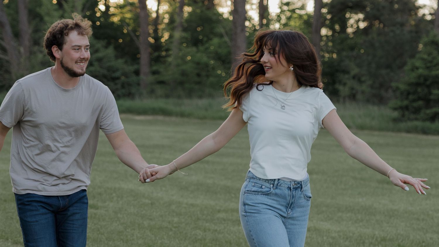 candid natural couple running through a field