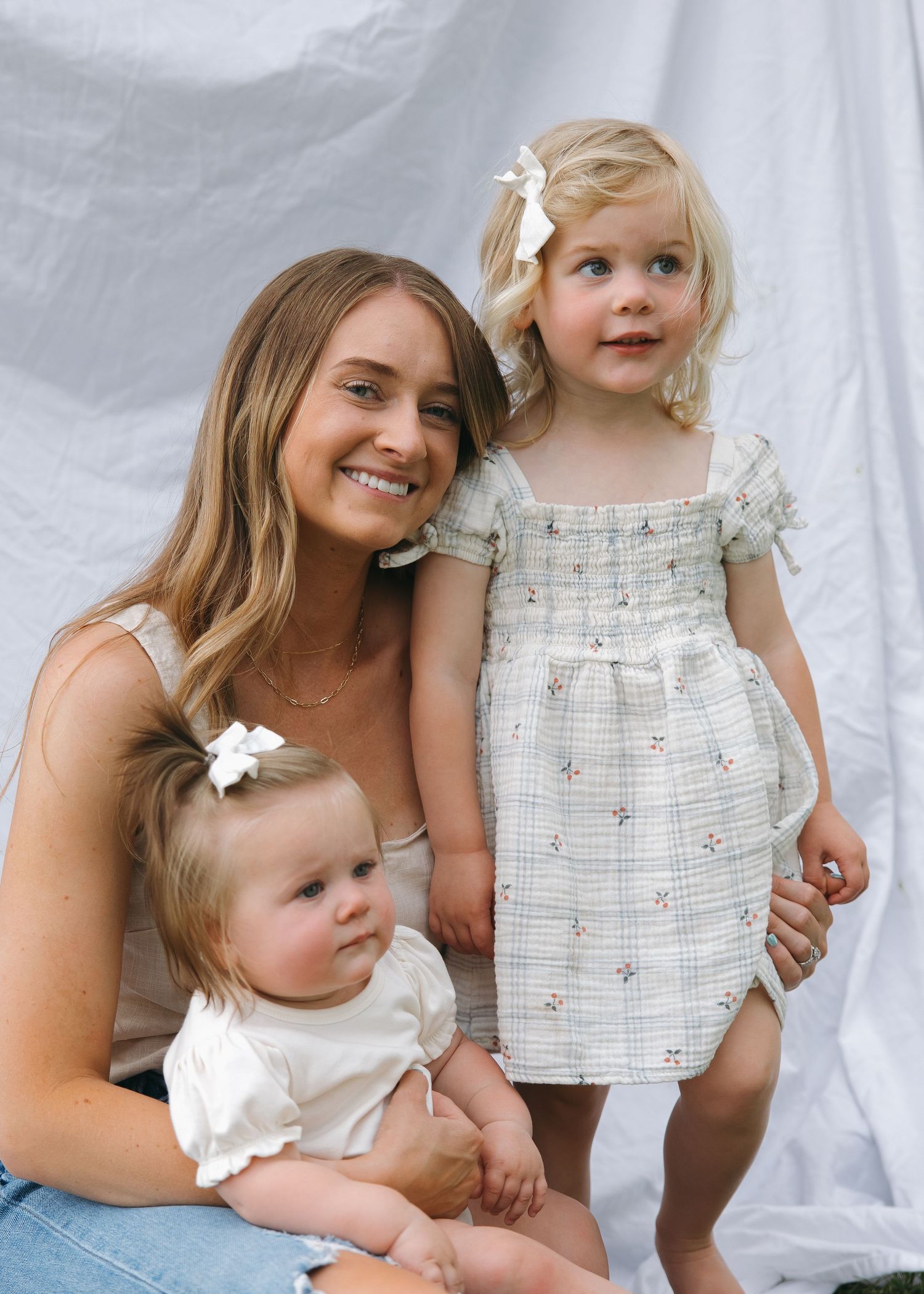 close up smiling mother and daughters outdoor relaxed family session