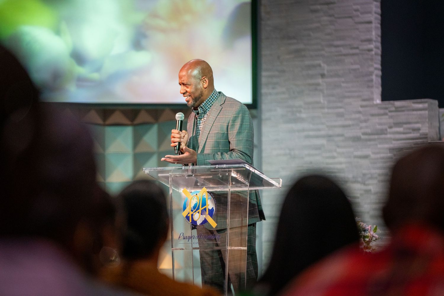 A speaker delivers a message from a transparent podium during a church service.