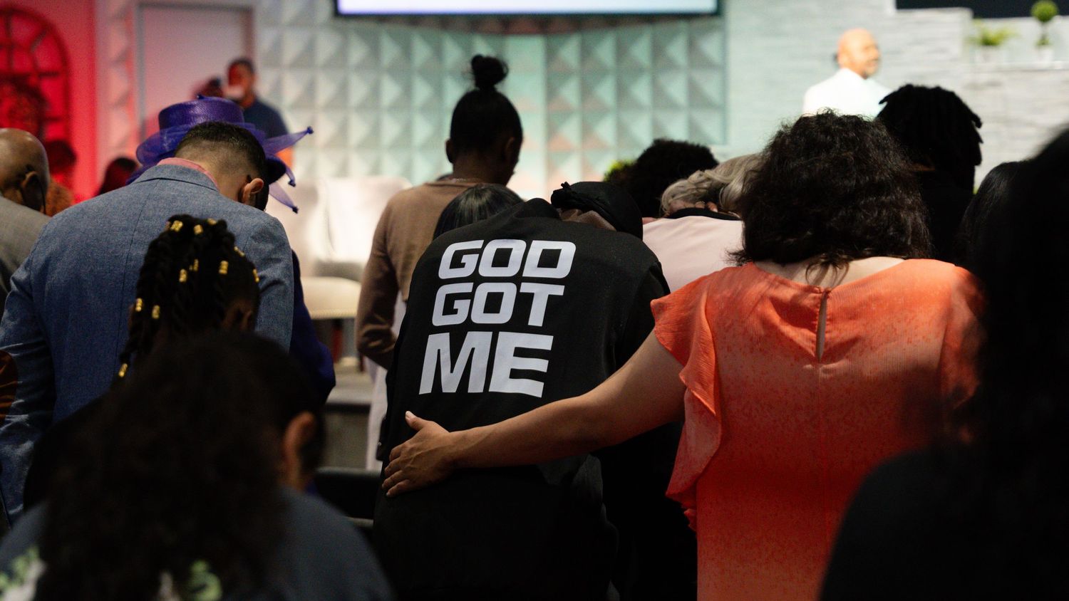 Audience members in matching t-shirts seated in rows at an indoor event venue.