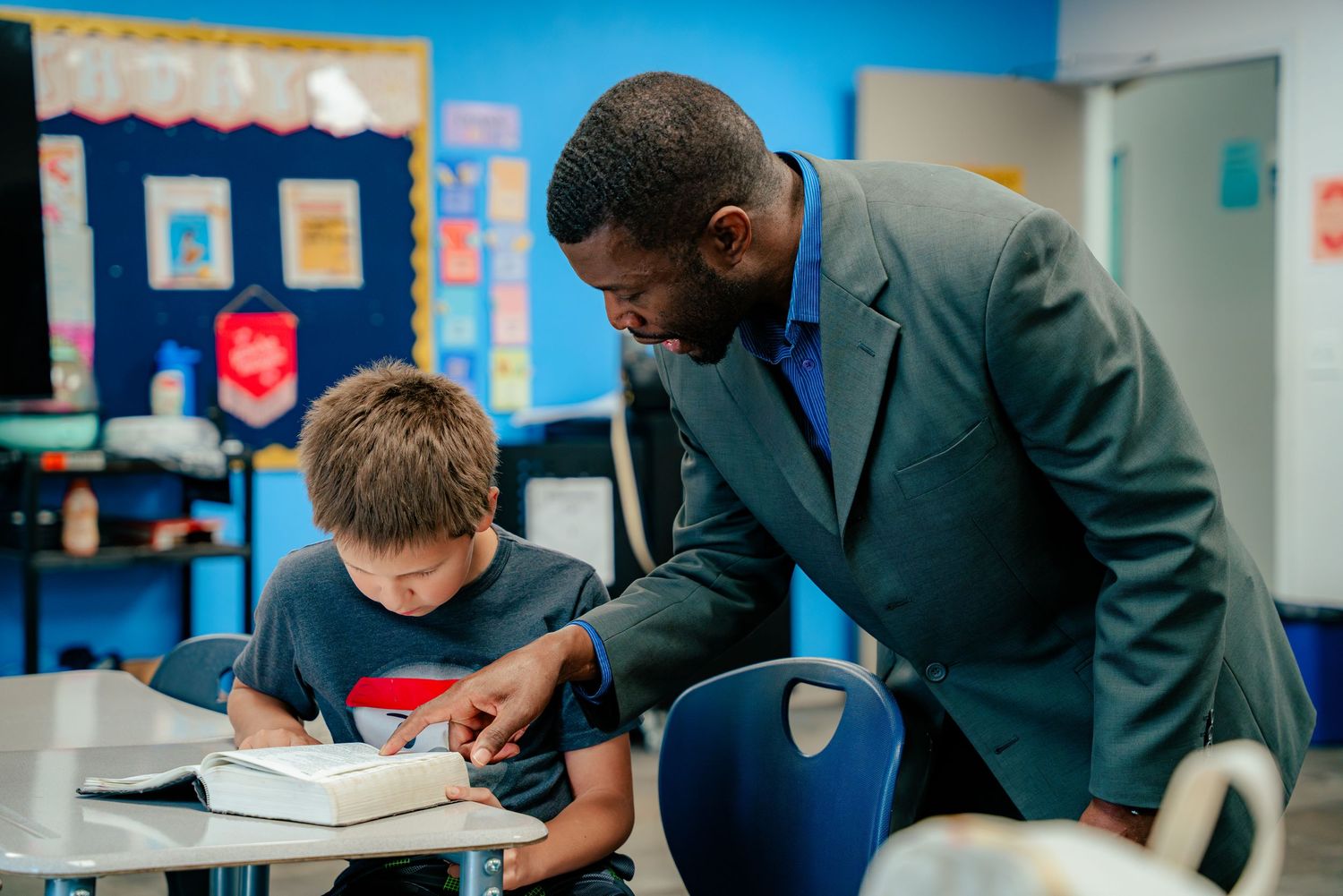 Educational mentoring session showing students working with instructors in a modern classroom.
