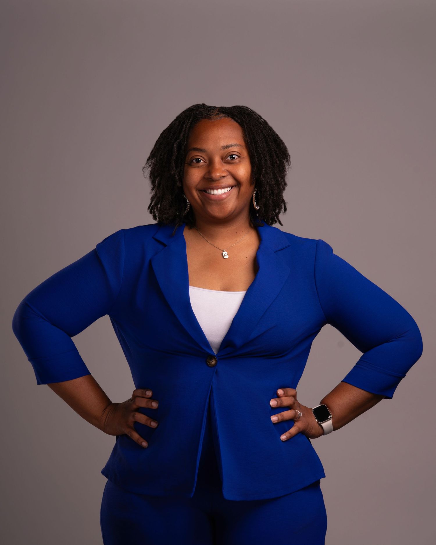 Professional portrait featuring a bright royal blue blazer and white top against a neutral backdrop.