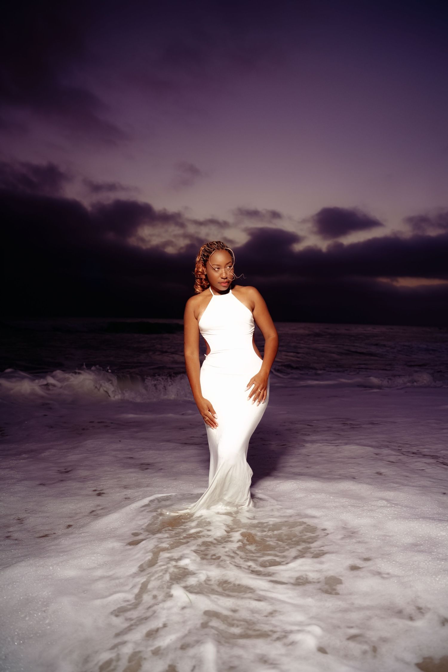 A series of sunset beach photos showing someone in a white dress standing in the ocean waves.