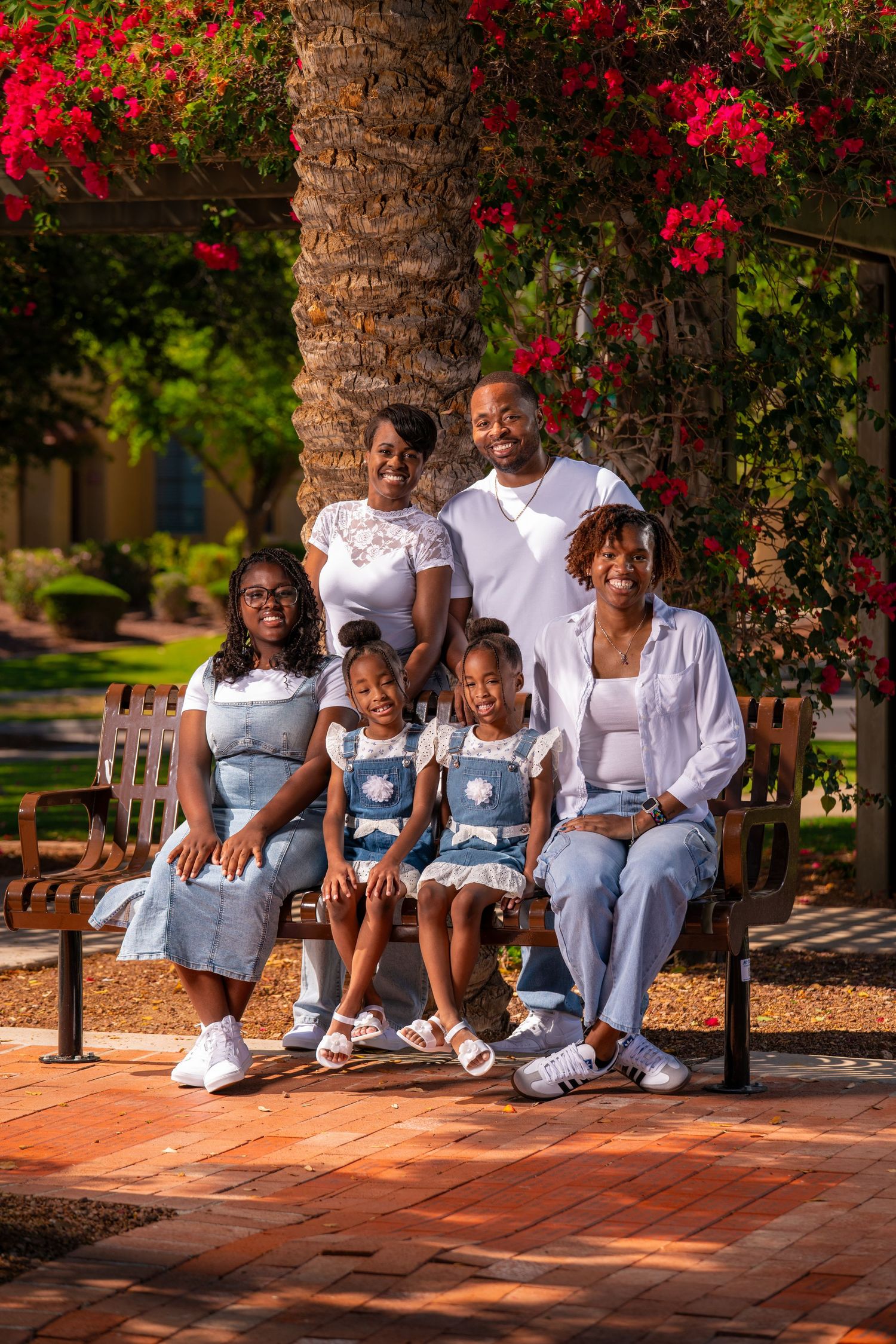 Extended family gathering photo with matching outfits seated on outdoor brick patio.