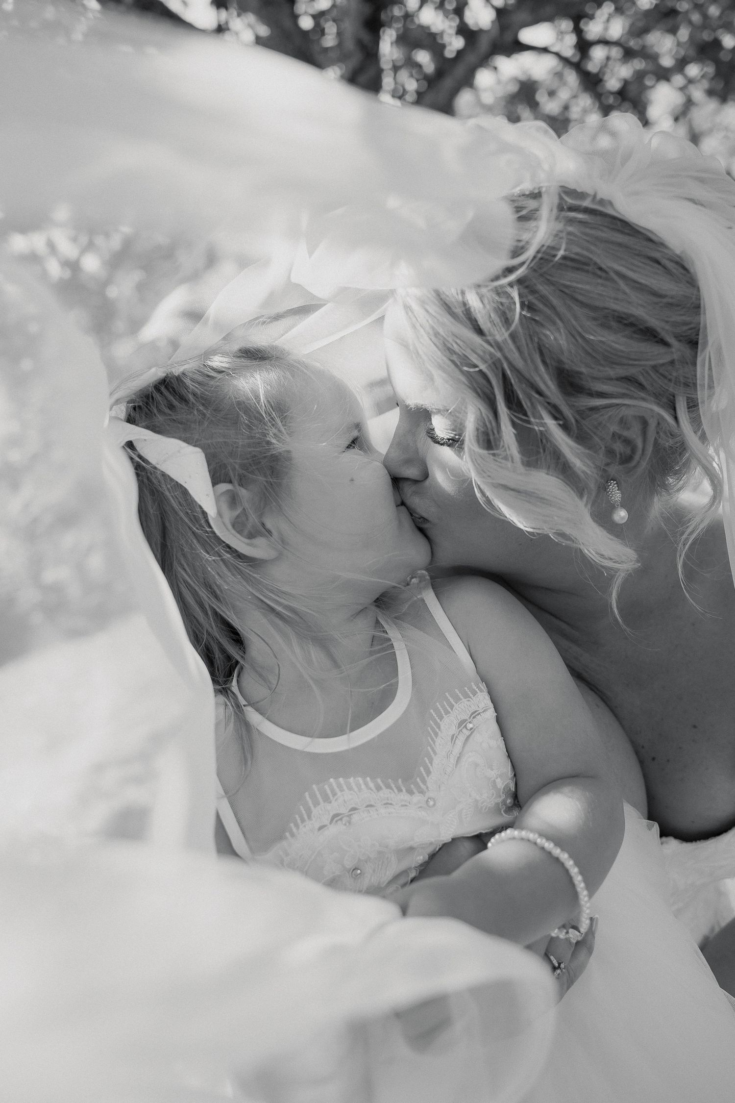 Bride and Daughter kissing under veil, South Devon