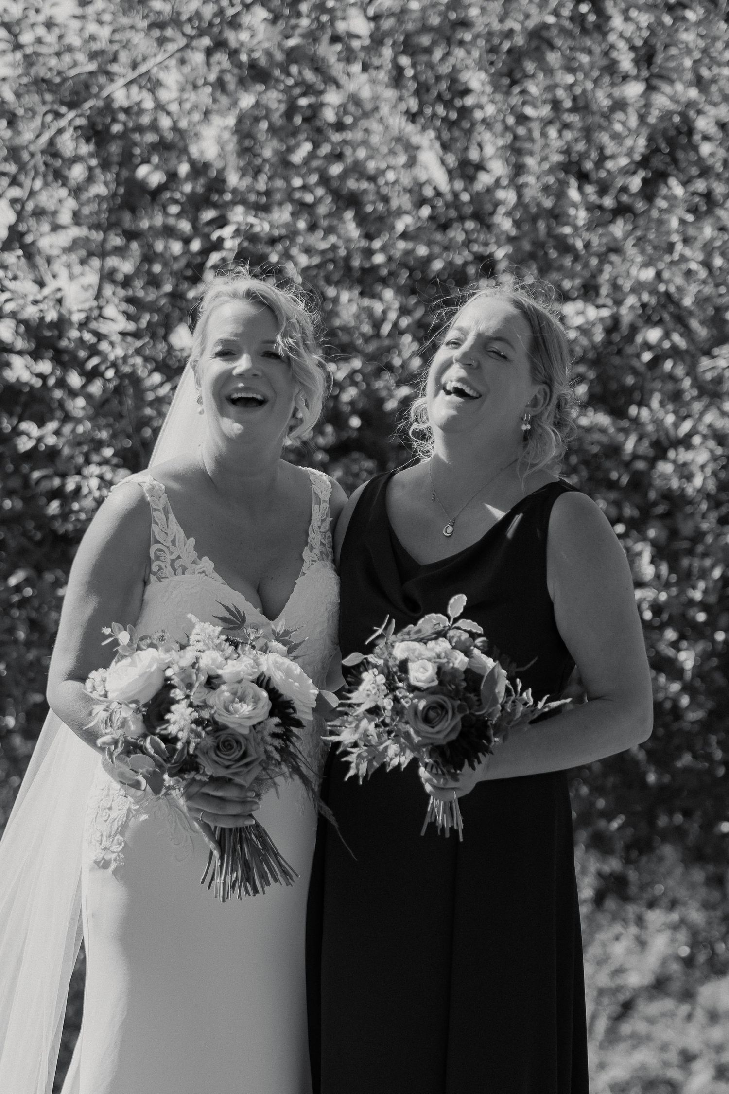 Bride and Sister laughing during group photos in South Devon Countryside