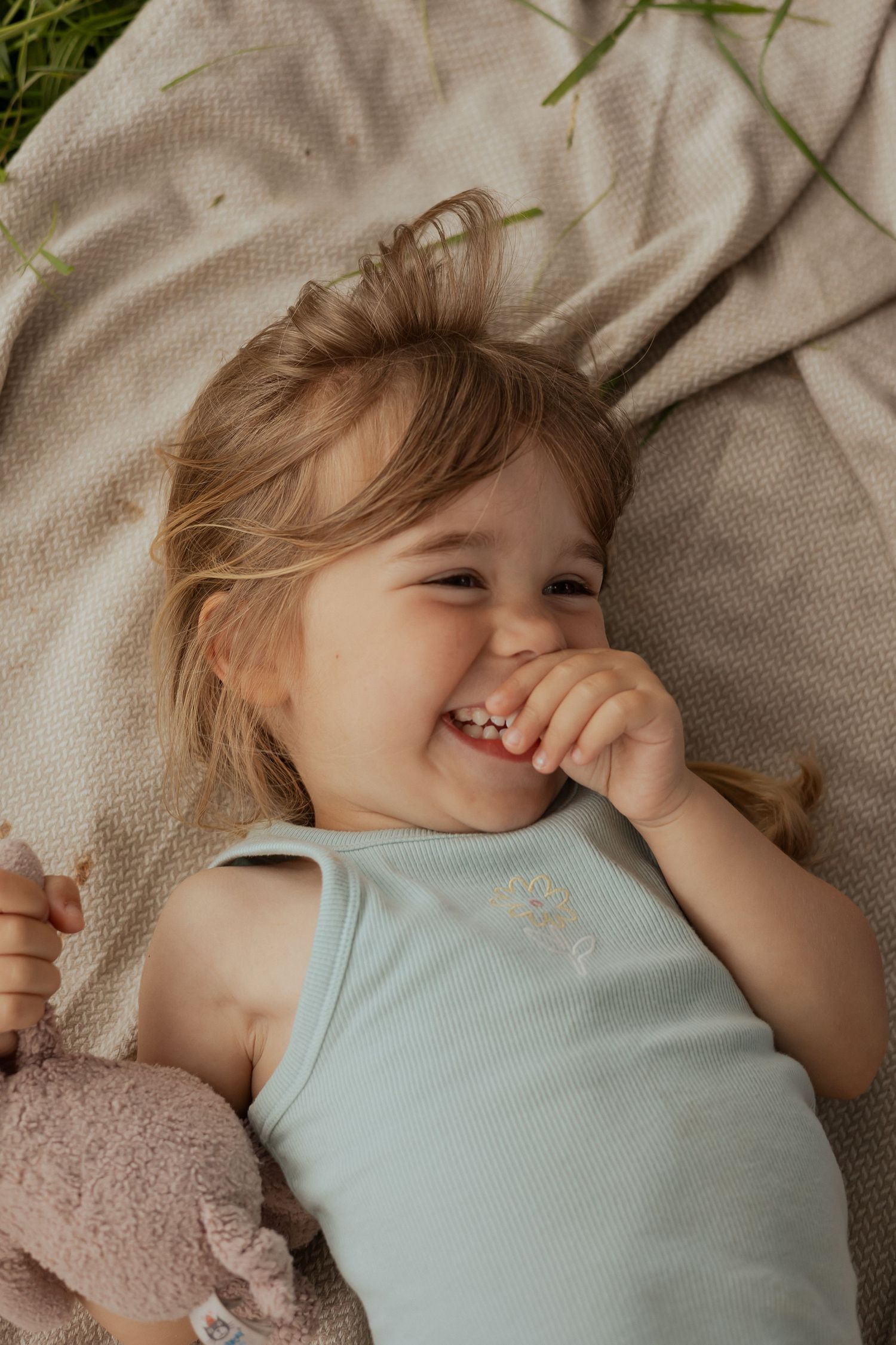 Child giggling at brothers during photo shoot in a South Devon meadow