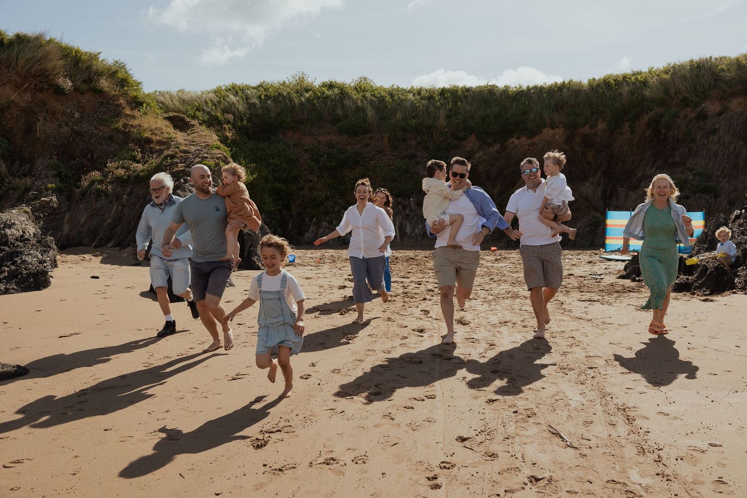 Extended Family session with children having fun on Bantham Beach during Spring in South Devon