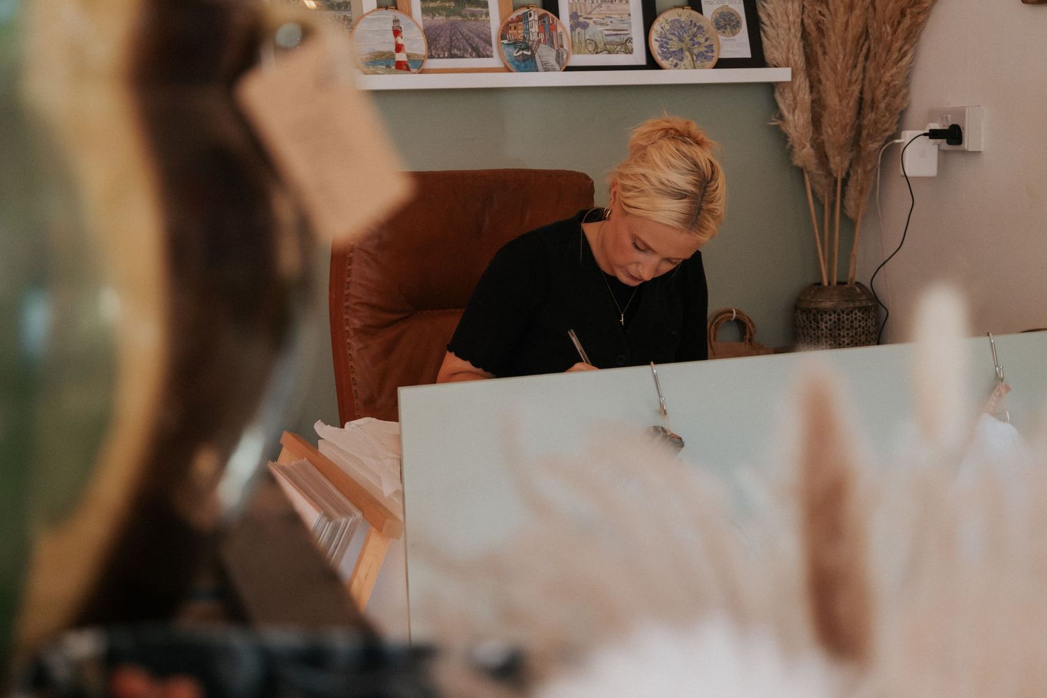 female small business owner working at desk during brand photoshoot in Kingsbridge