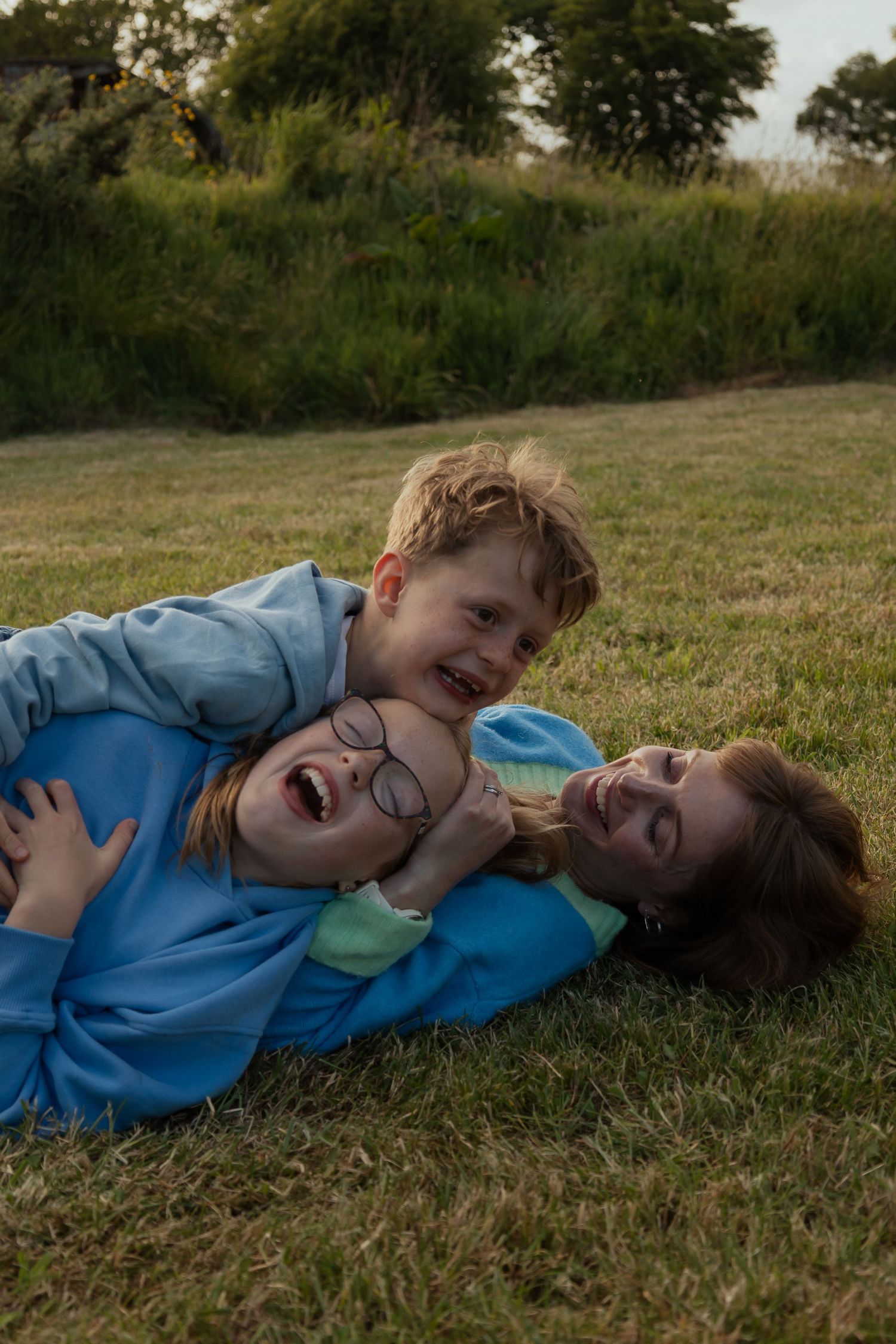 Mother and children playing during a laid back family session at their family farm in South Devon