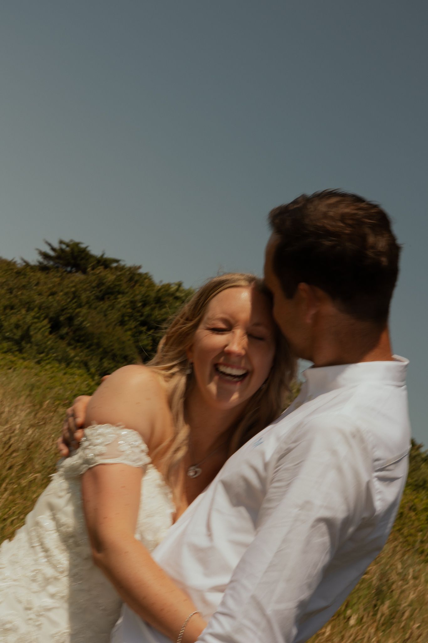 Newlyweds laughing during golden hour in Wembury, South Devon
