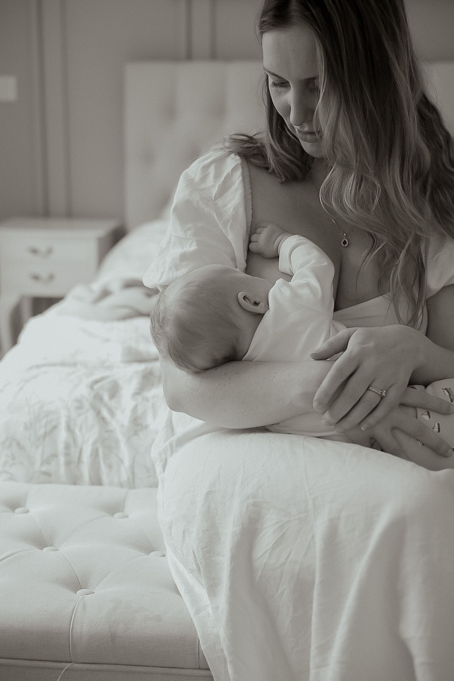 Mother holding newborn in natural light during South Devon family photoshoot