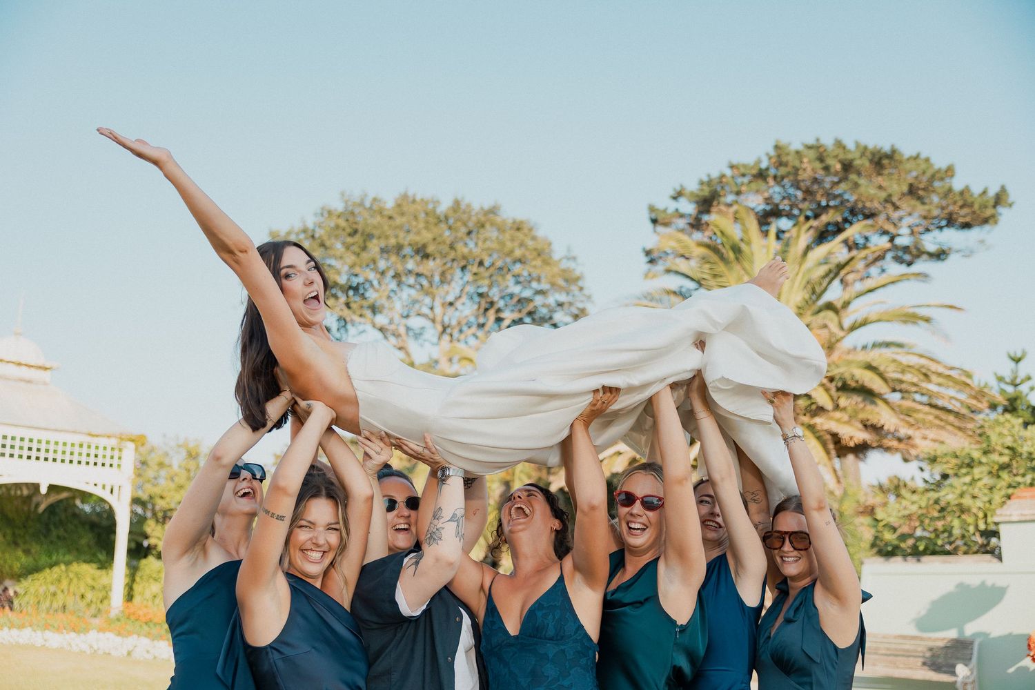 Bridesmaids holding up bride for fun photos in Falmouth, Cornwall