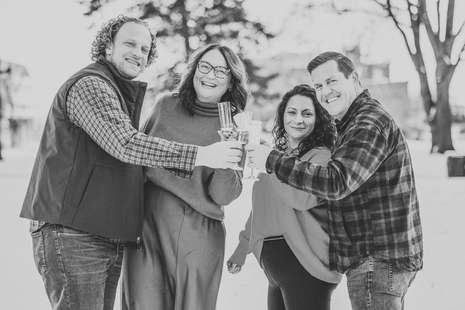 A black and white photo collage showing a couple laughing and embracing outdoors in casual plaid clothing.