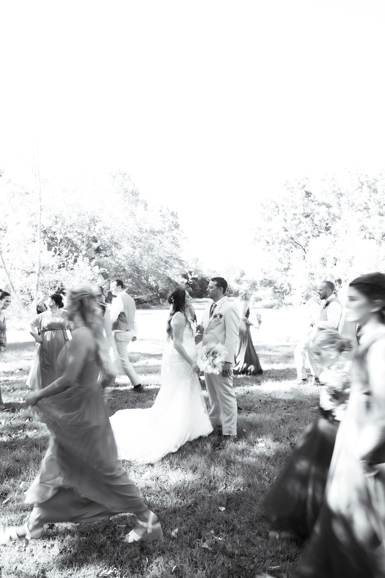 A series of blurry black and white photographs showing people moving in an outdoor setting.